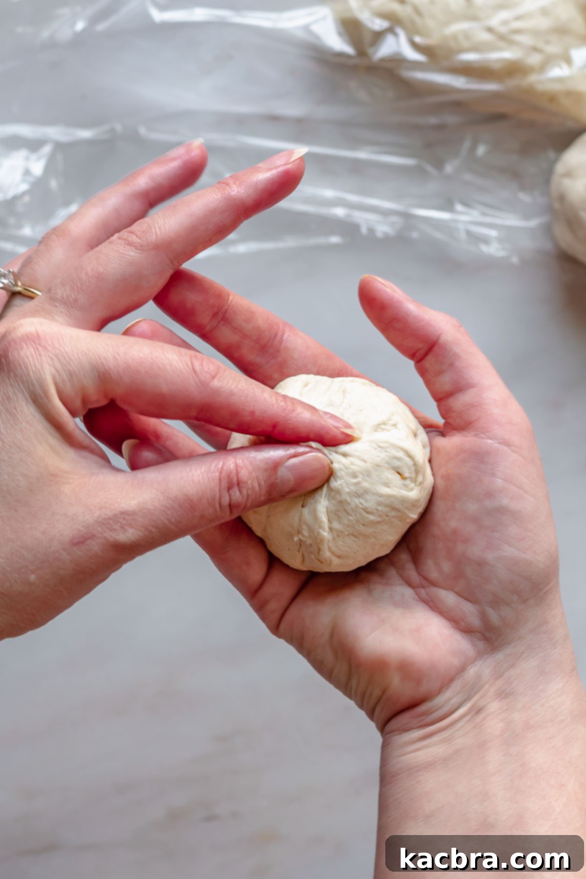 Savory Pimento Pretzel Twists 10 Hands carefully pinching together the edges of the pretzel dough over the pimento cheese filling to seal it.