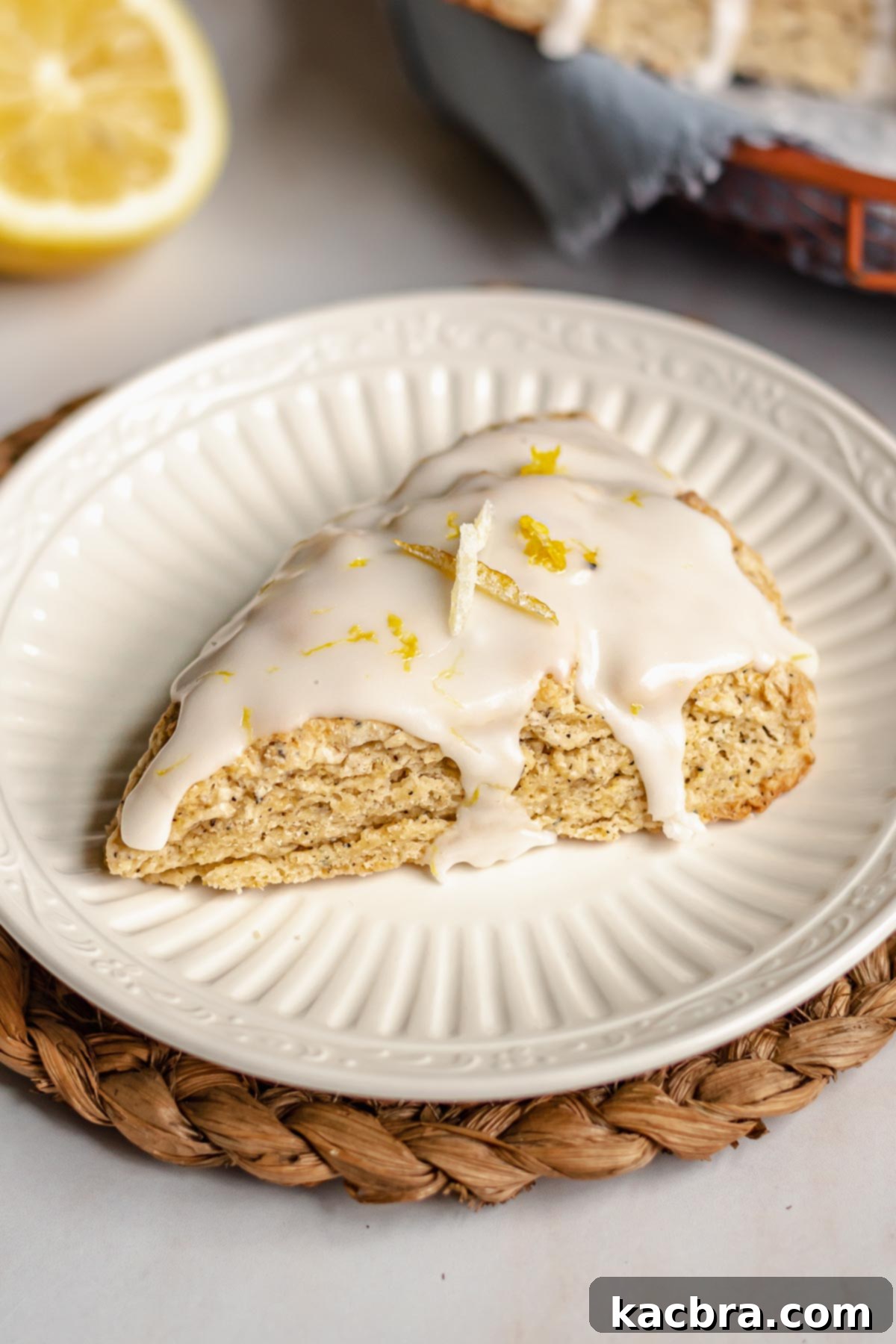 Bergamot Scones with Tangy Lemon Glaze 11 A single Earl Grey scone on a white plate, ready to be eaten.