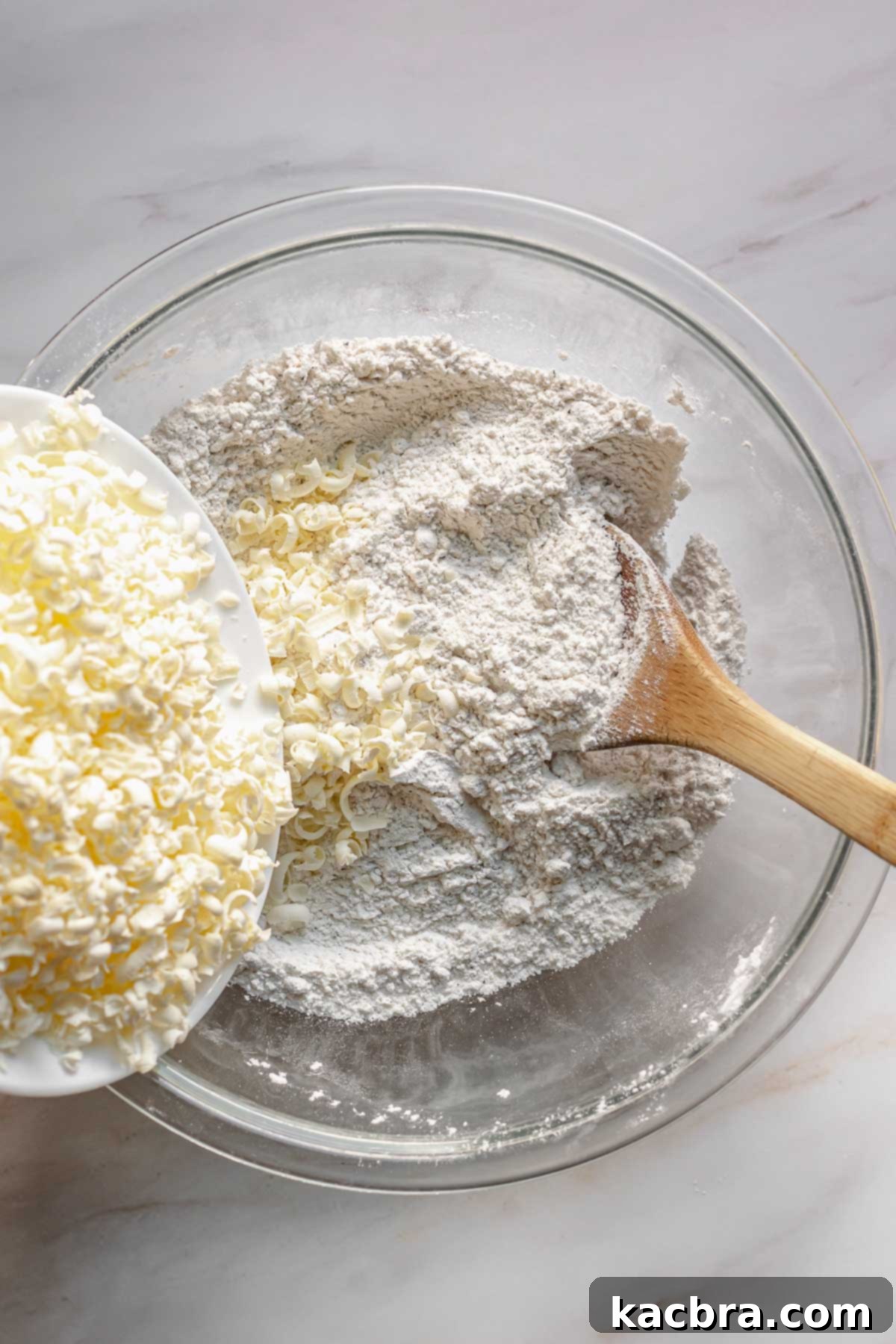 Bergamot Scones with Tangy Lemon Glaze 5 Grated butter being added to flour in a bowl.