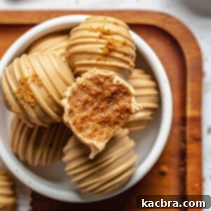 Irresistible Biscoff Cookie Truffles 14 A bite removed from a biscoff truffle, showing its creamy interior.