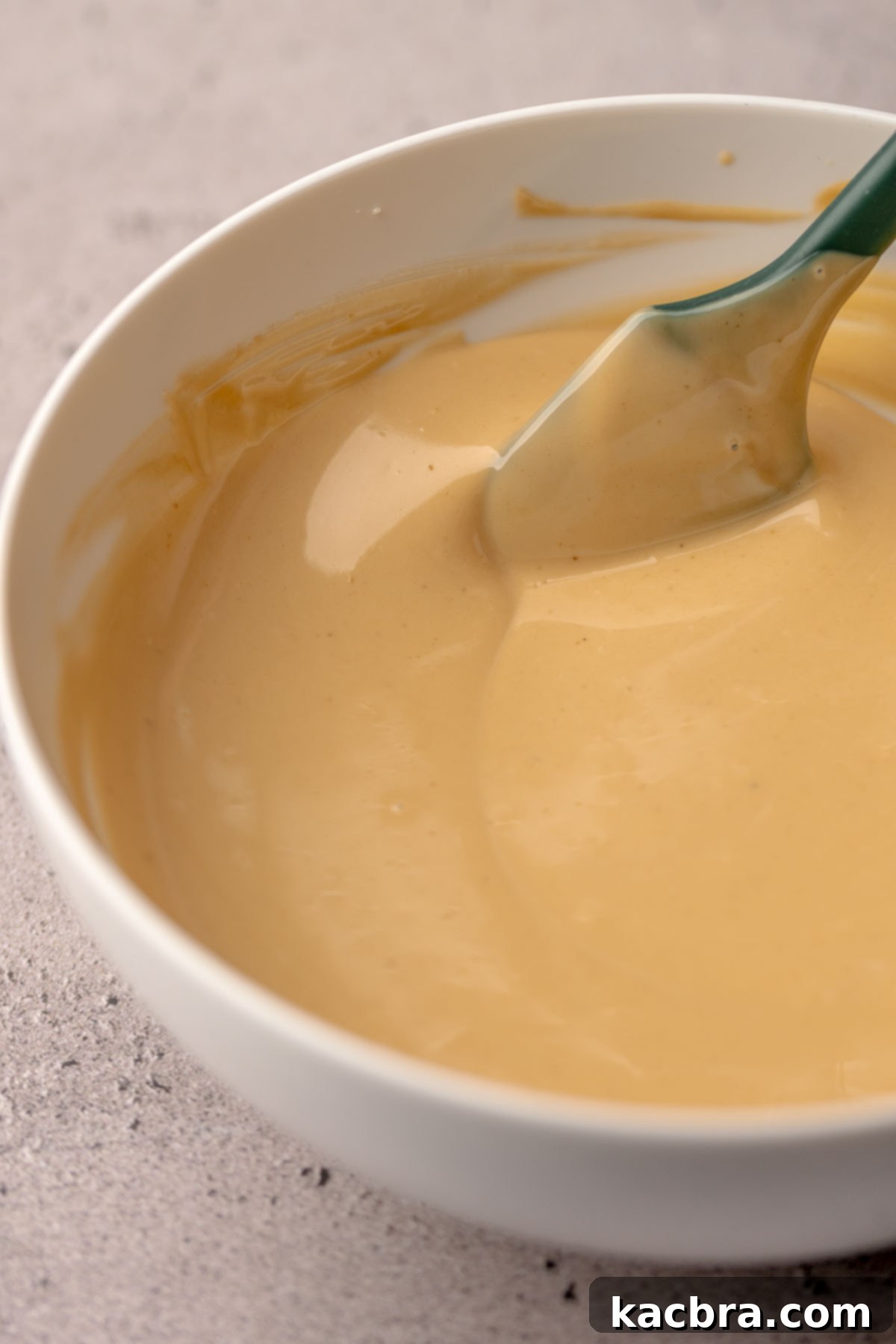 Irresistible Biscoff Cookie Truffles 9 Melted Biscoff spread and white chocolate mixture in a bowl, ready for dipping.