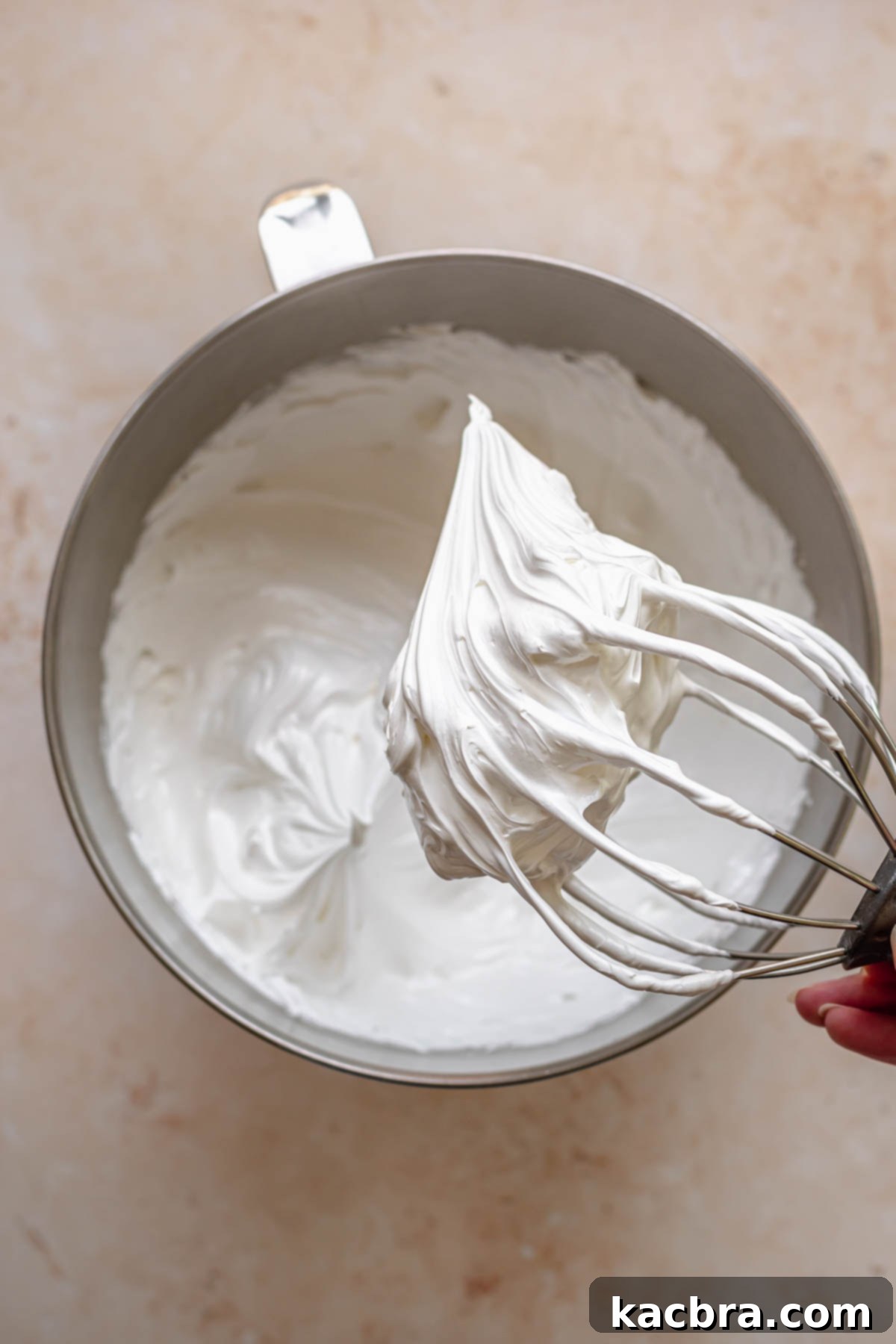 Whipped Swiss meringue on a whisk.