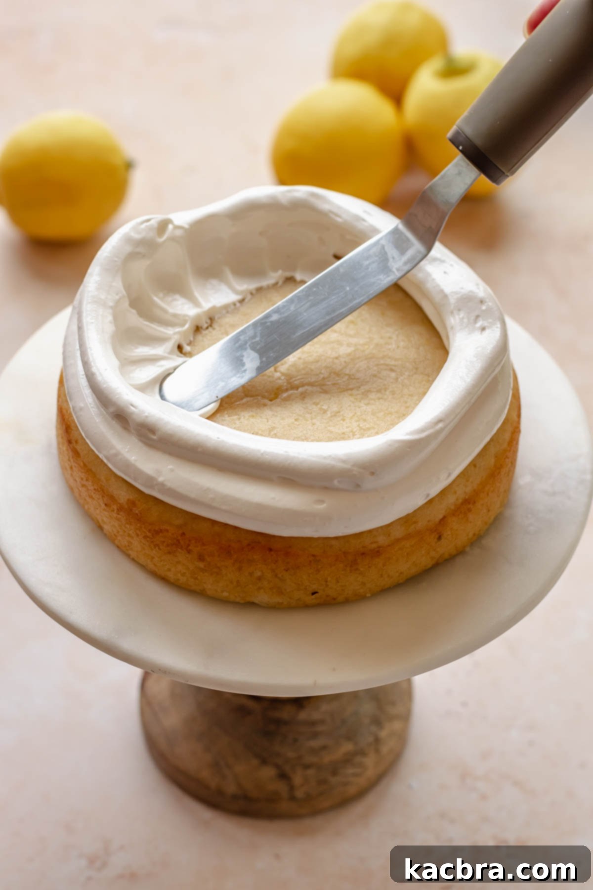 An offset spatula pulls meringue into the center of the cake.