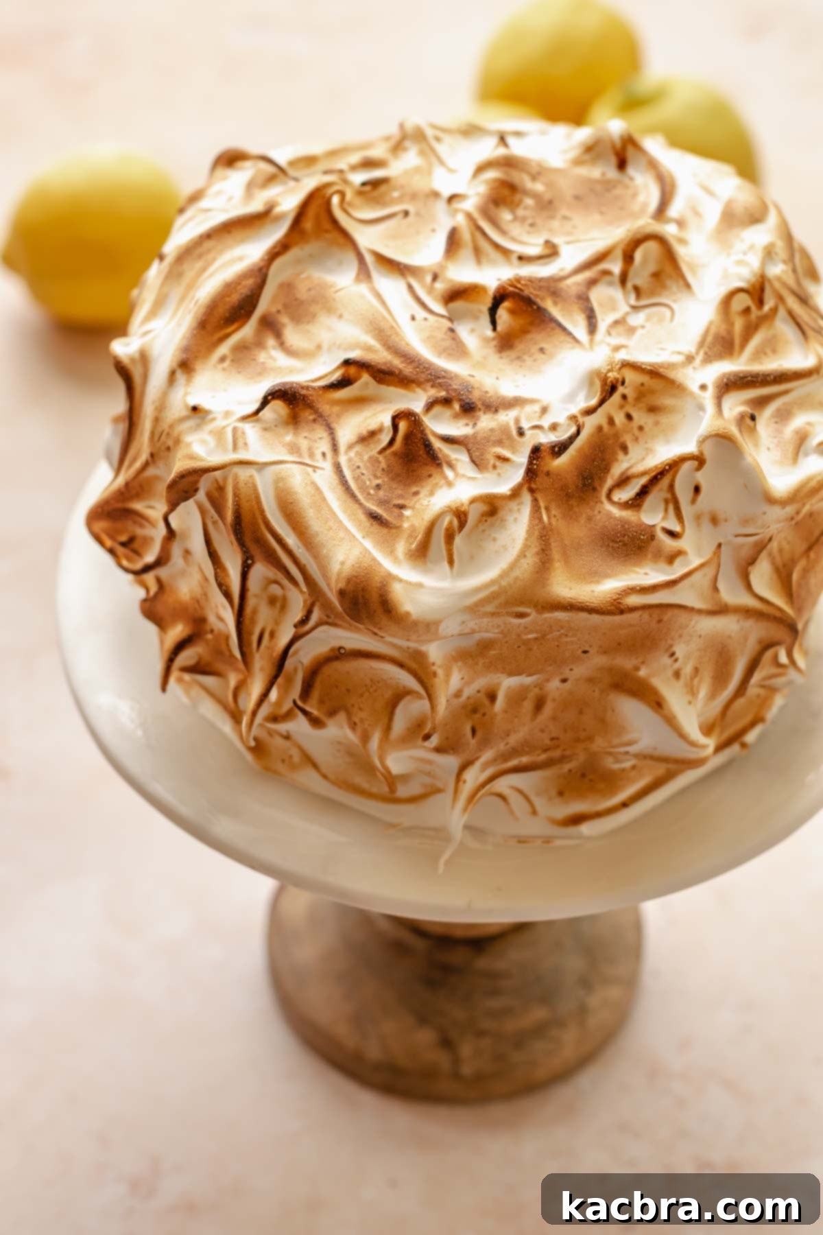 Torched lemon meringue cake on a cake stand.