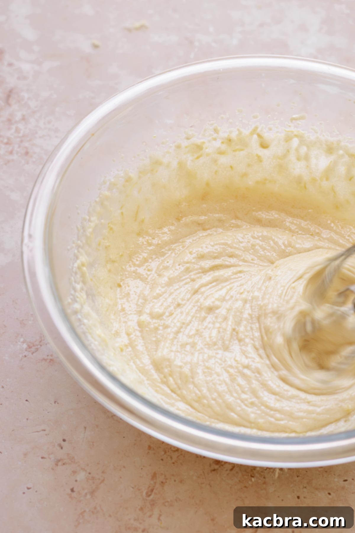 Beaters cream the base of cake batter in a bowl.