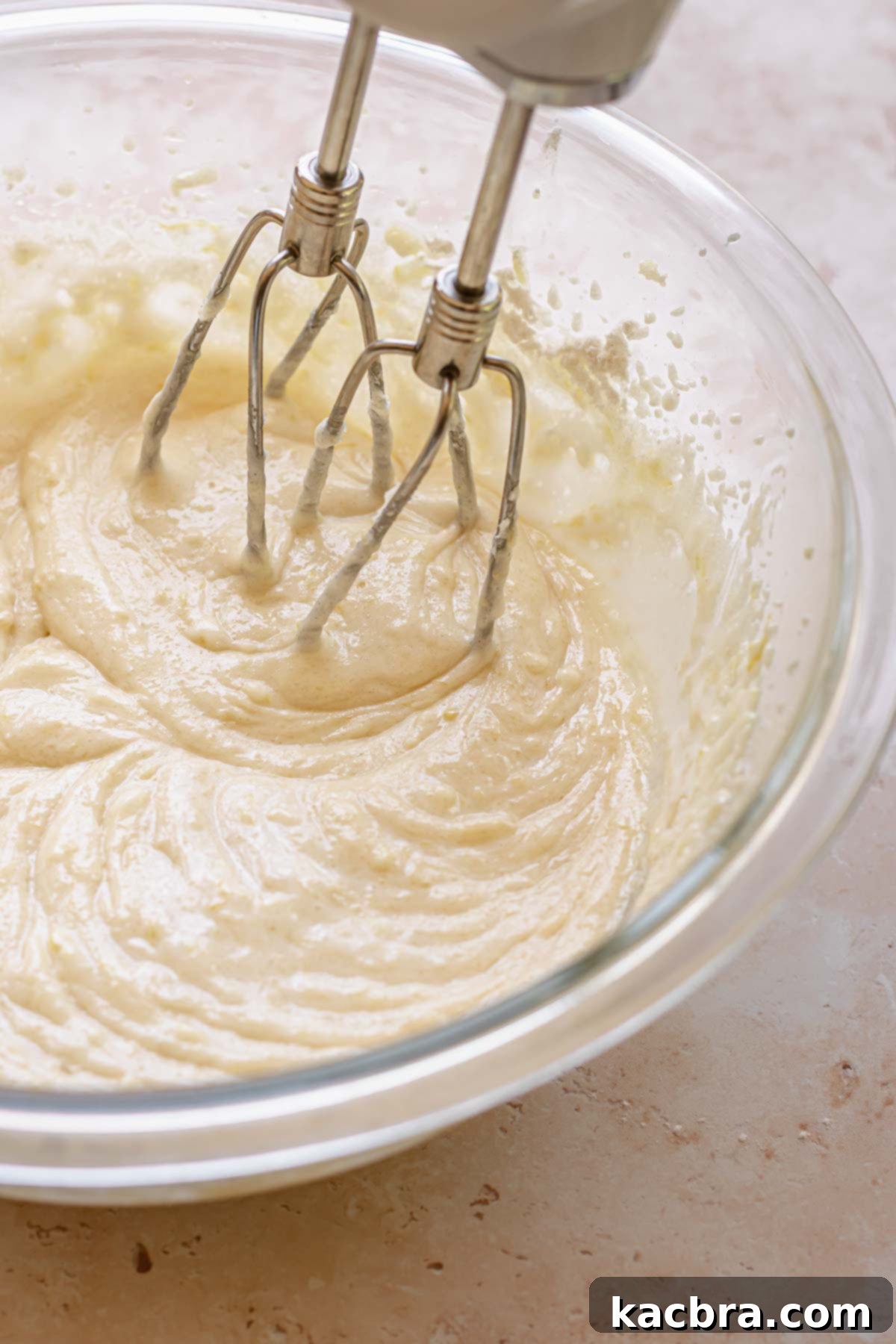 Beaters mix cake batter base in a bowl.