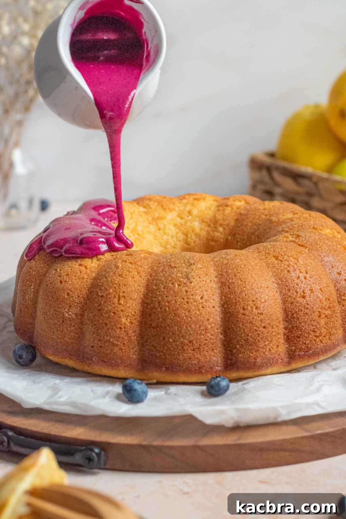 Blueberry glaze being poured onto a Bundt Cake.