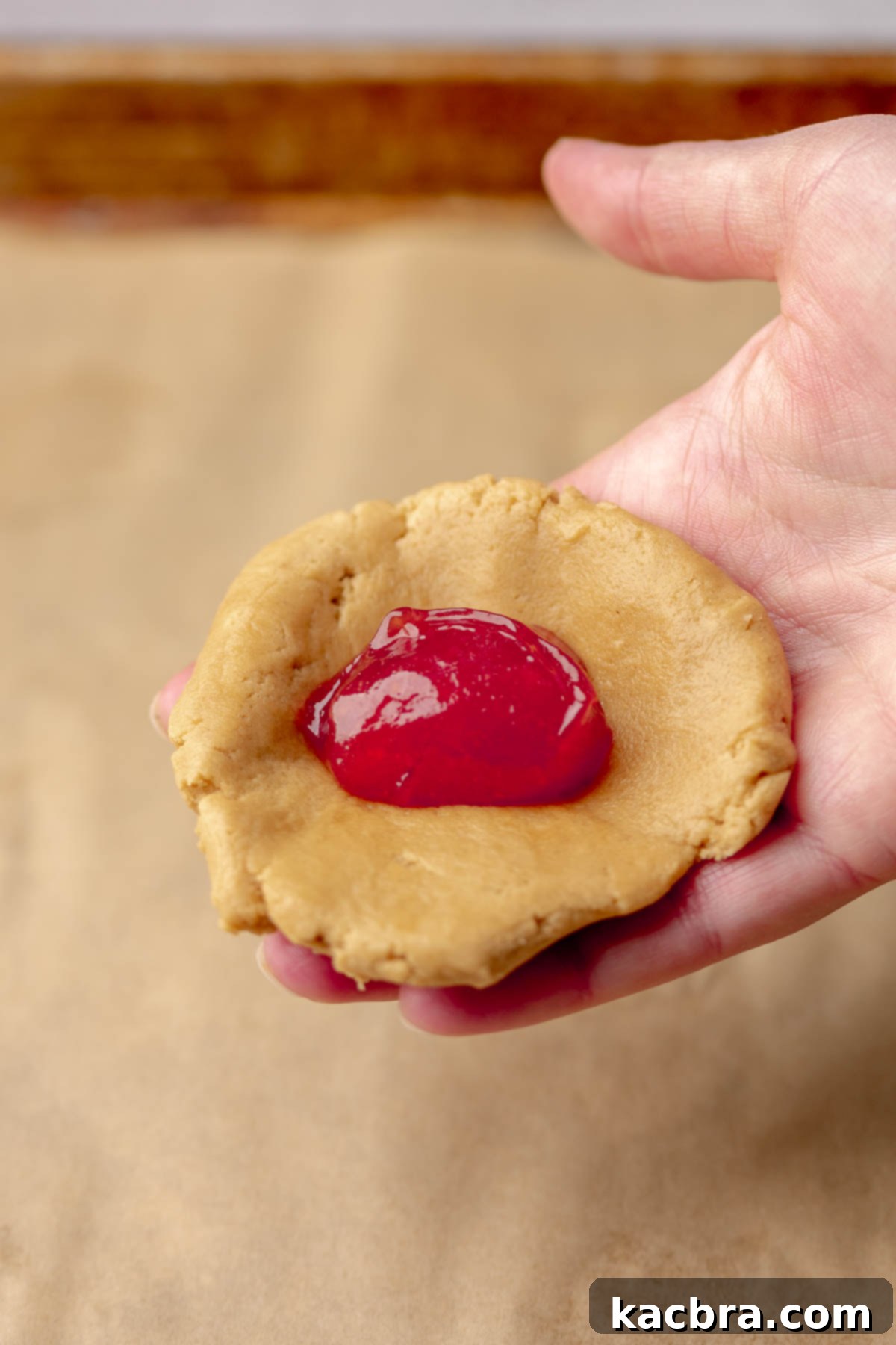 Jammy Peanut Butter Delights 11 Flattened peanut butter cookie dough with a dollop of thickened jelly in the center.