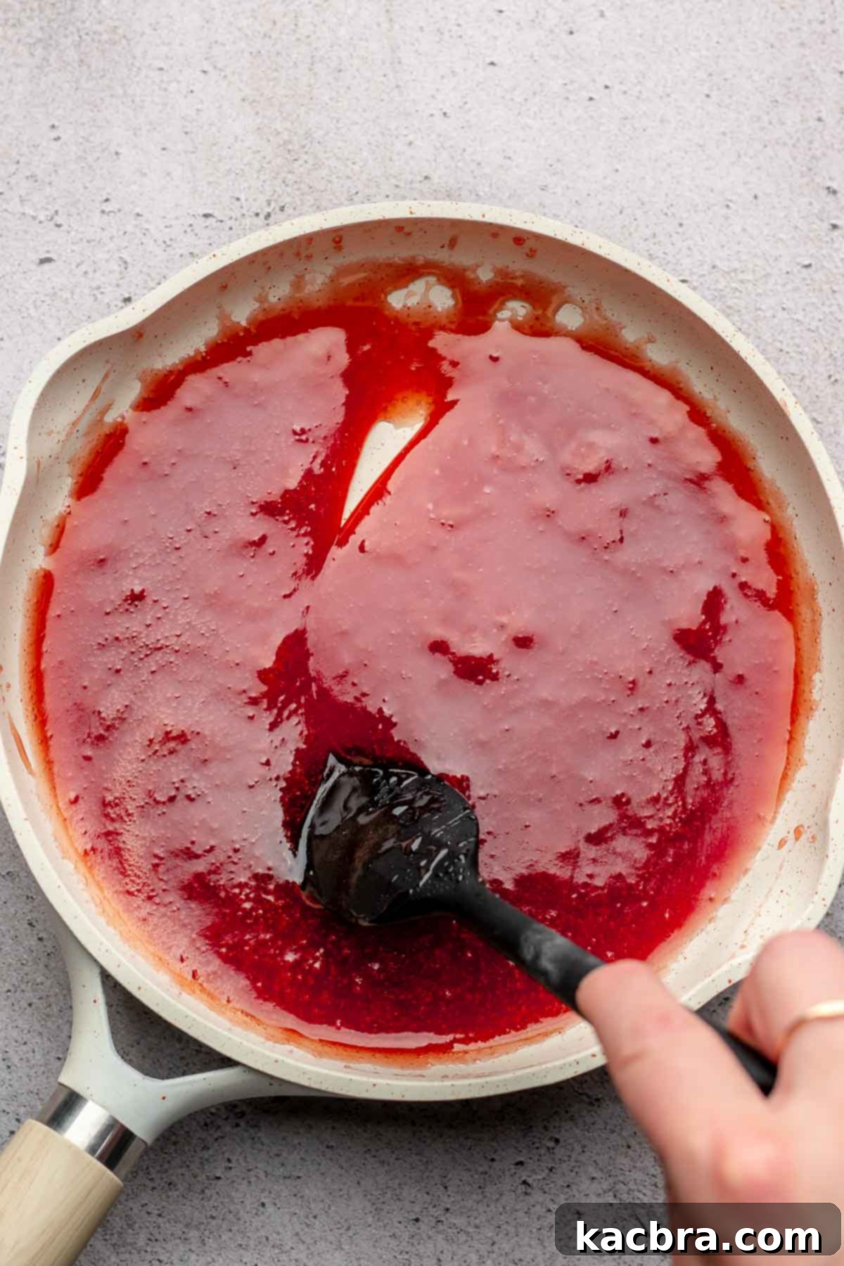 Jammy Peanut Butter Delights 4 A spatula runs through thickened strawberry jam in a pan, indicating it's ready for cooling.