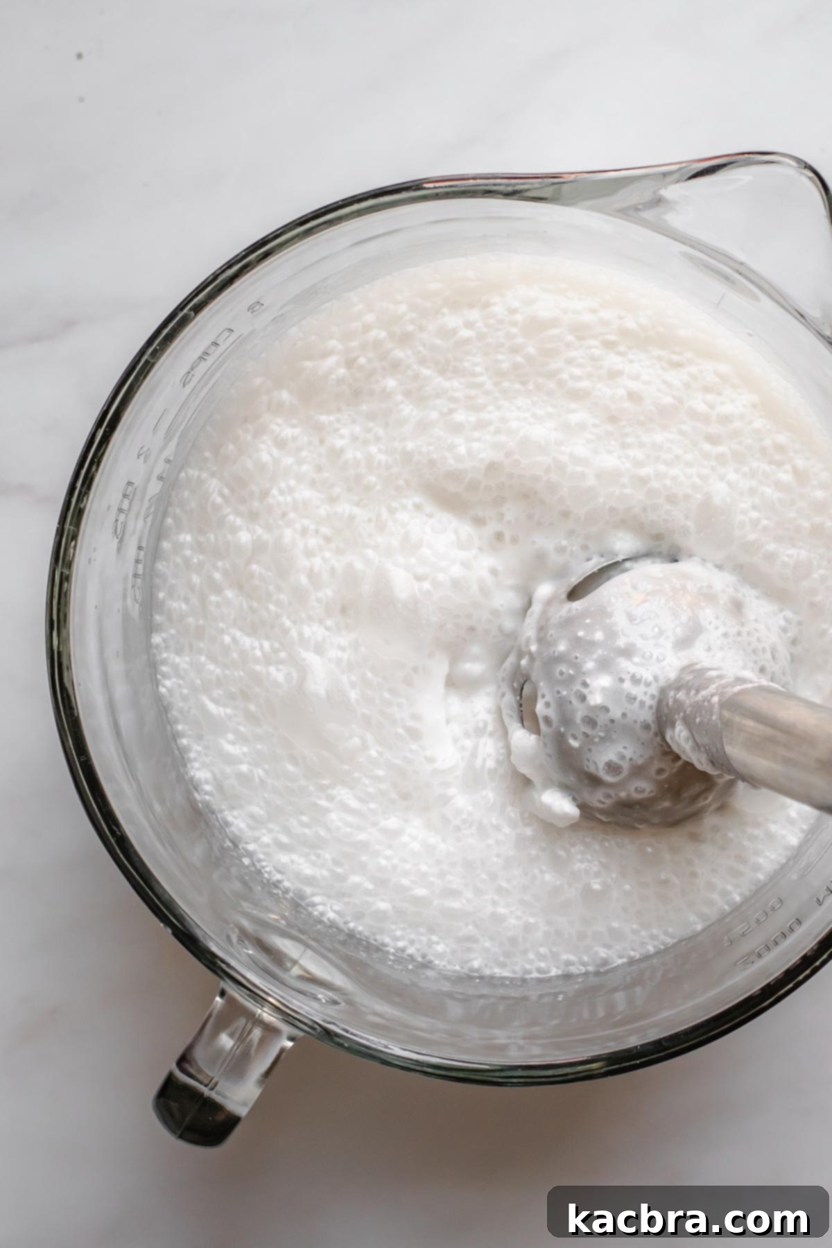 An immersion blender smoothly combines the coconut milk, cream, and simple syrup mixture.