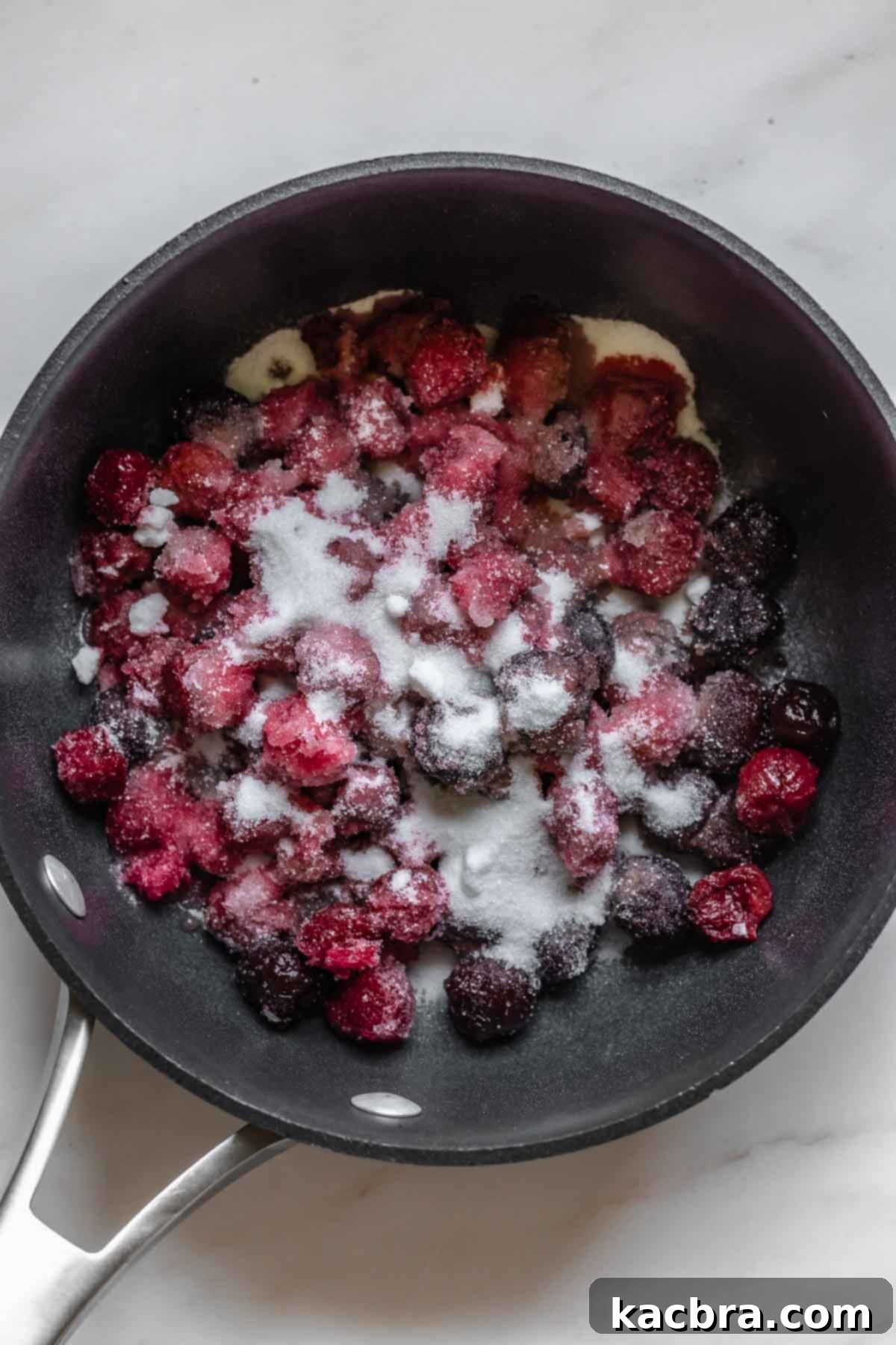 Cherries, sugar, and water simmering in a saucepan over medium heat.
