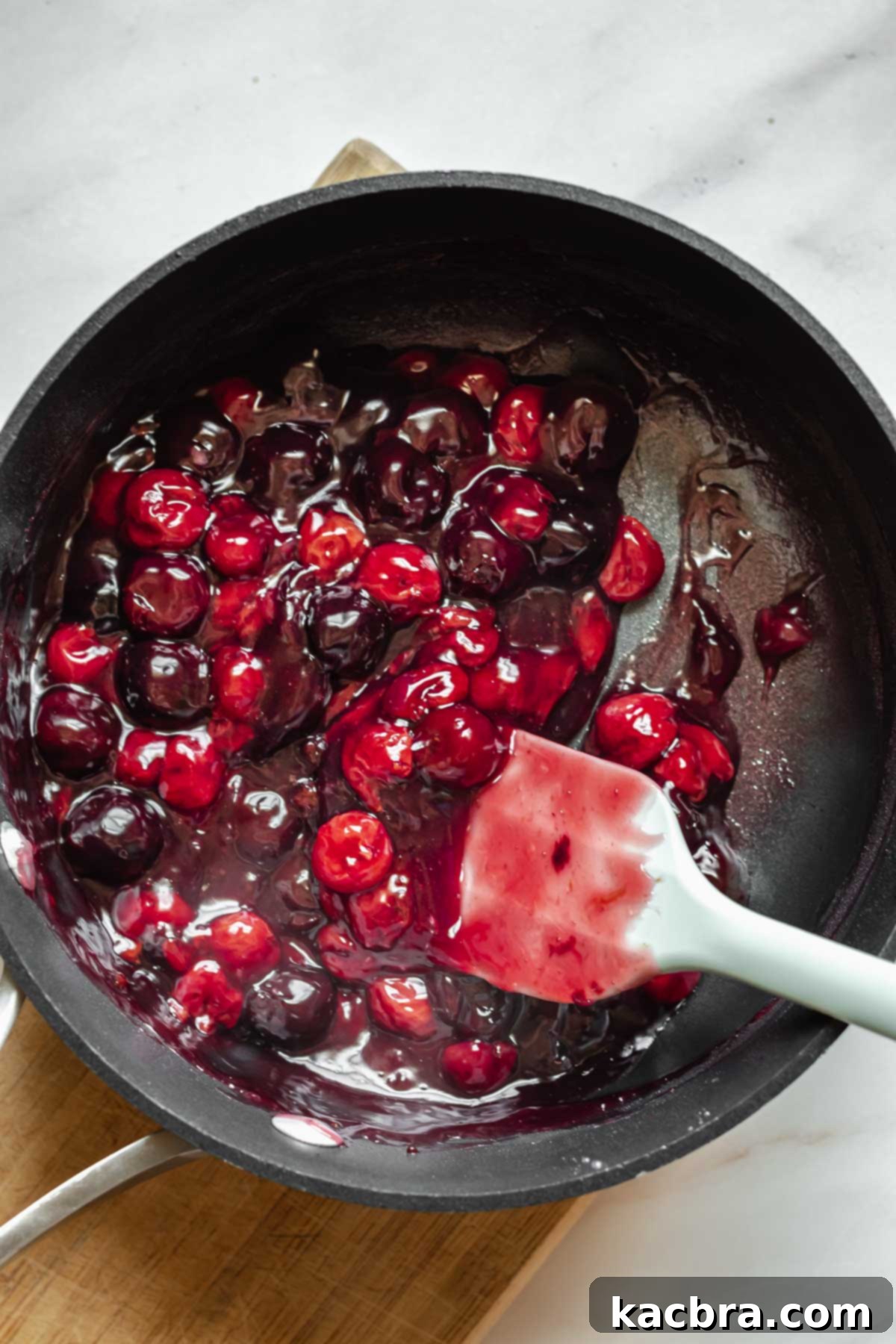 Thickened and cooked cherry pie filling in a saucepan.