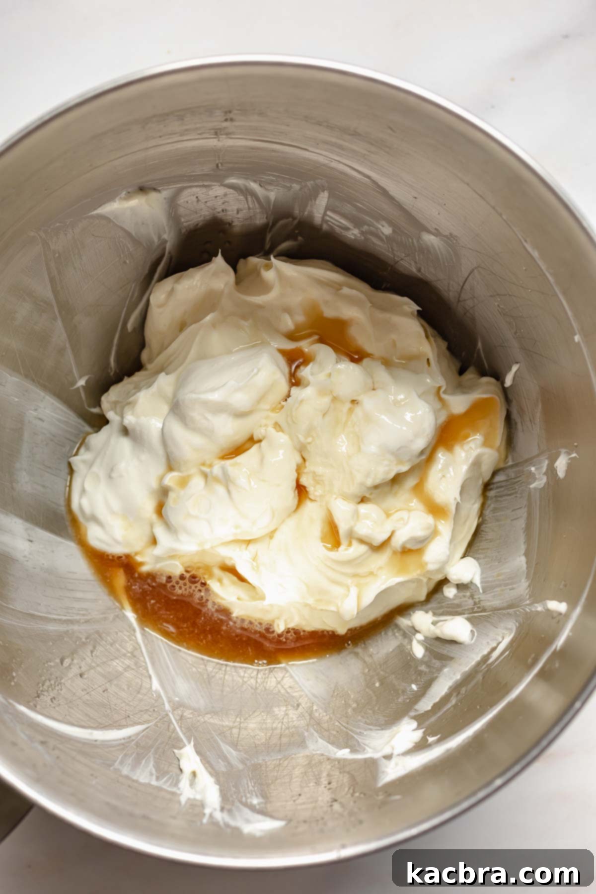 The mixed cream cheese, sugar, and vanilla extract in a bowl, appearing smooth and uniform.