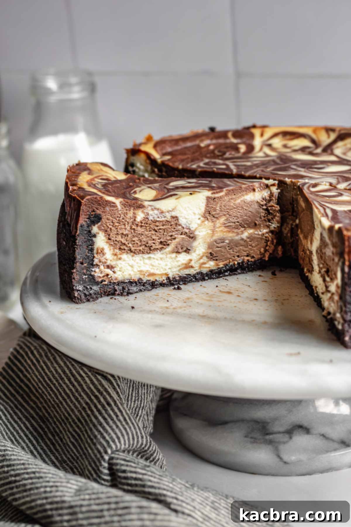 Chocolate marble cheesecake on a platter, showcasing the beautiful interior swirls and crunchy Oreo crust after slicing.