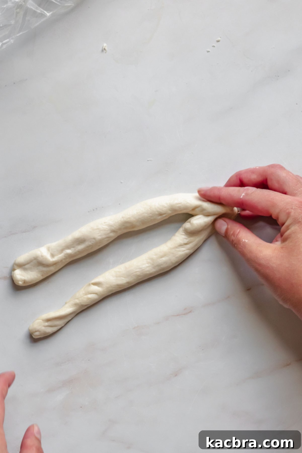 Pinching pretzel dough edges together.
