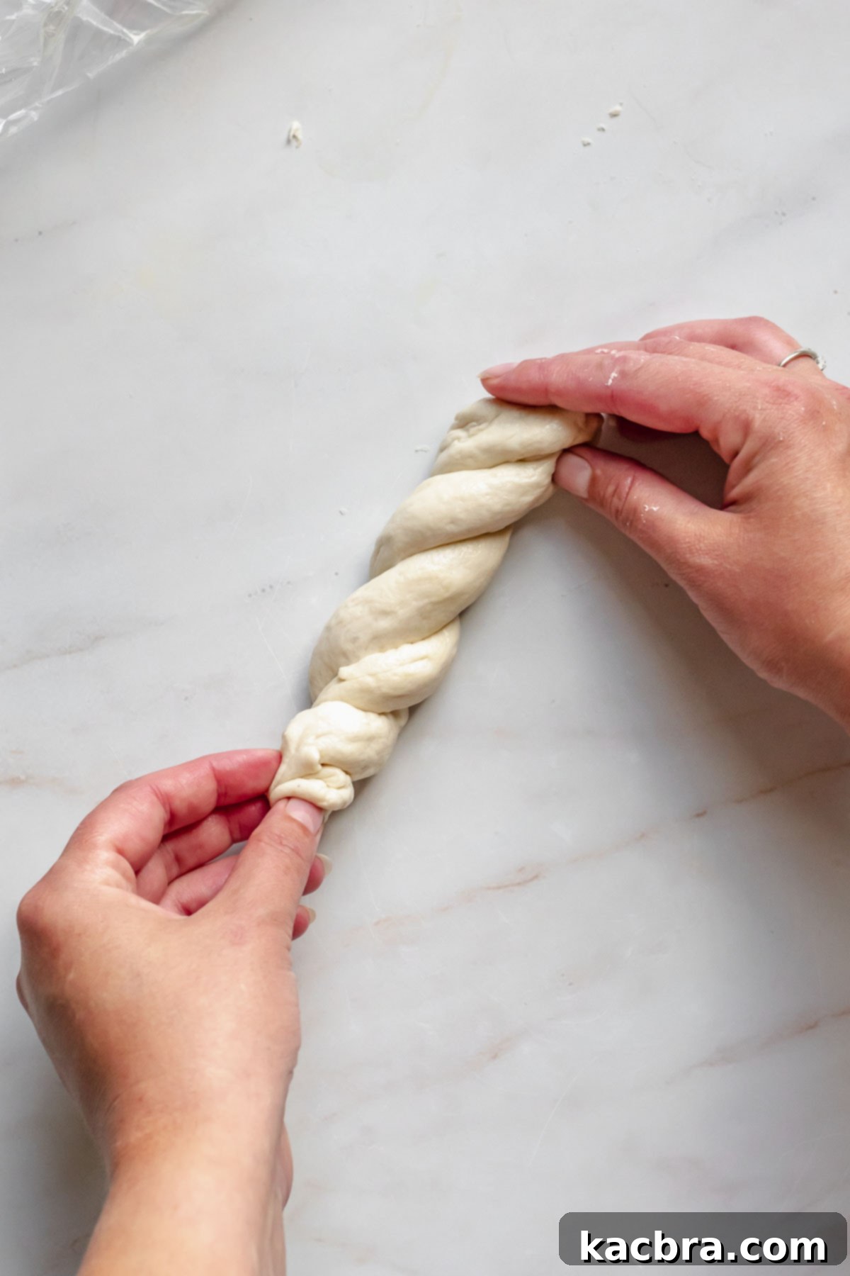 Twisting pretzel dough with two hands.