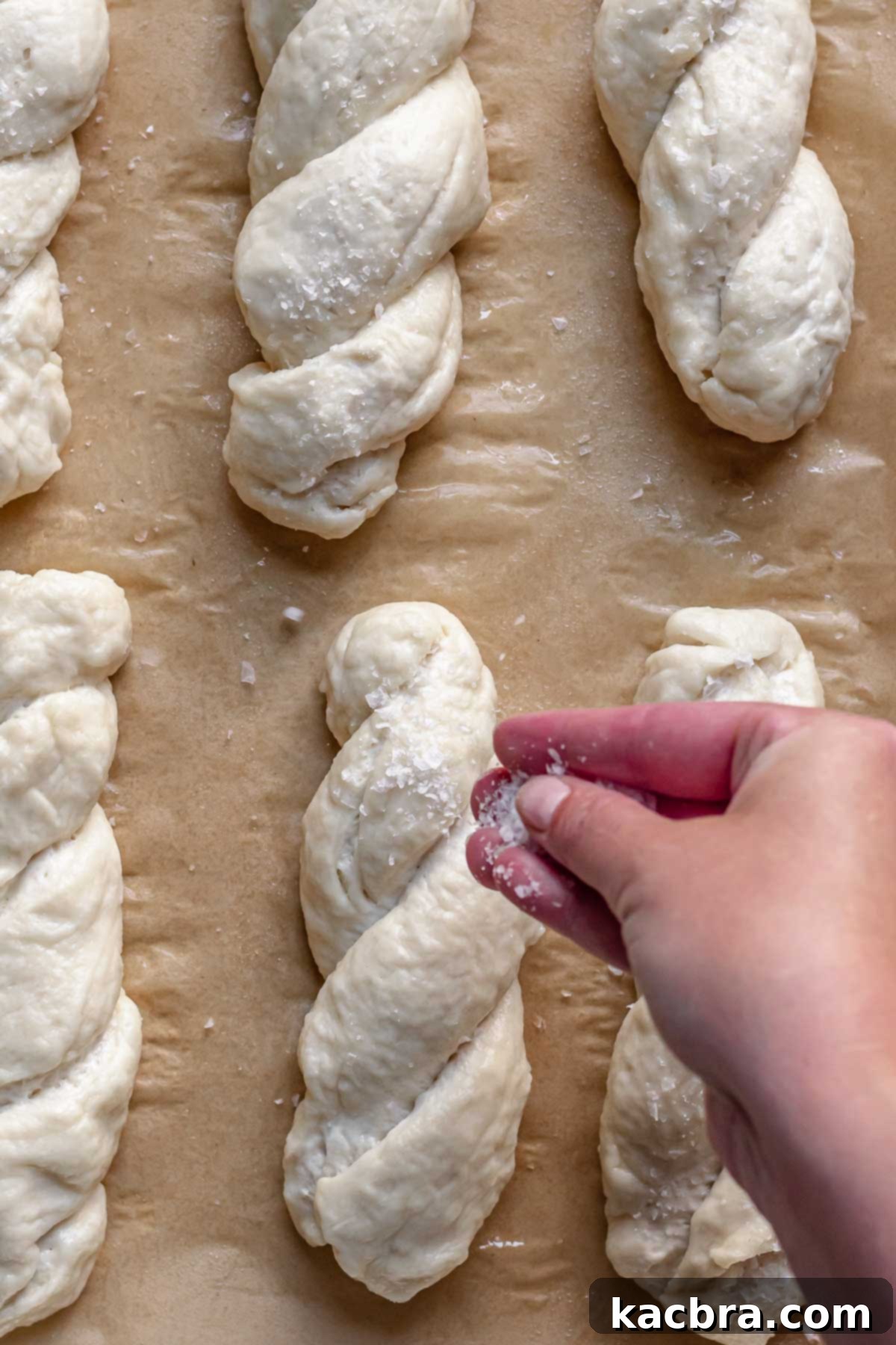 Adding salt to pre-baked pretzel dough.