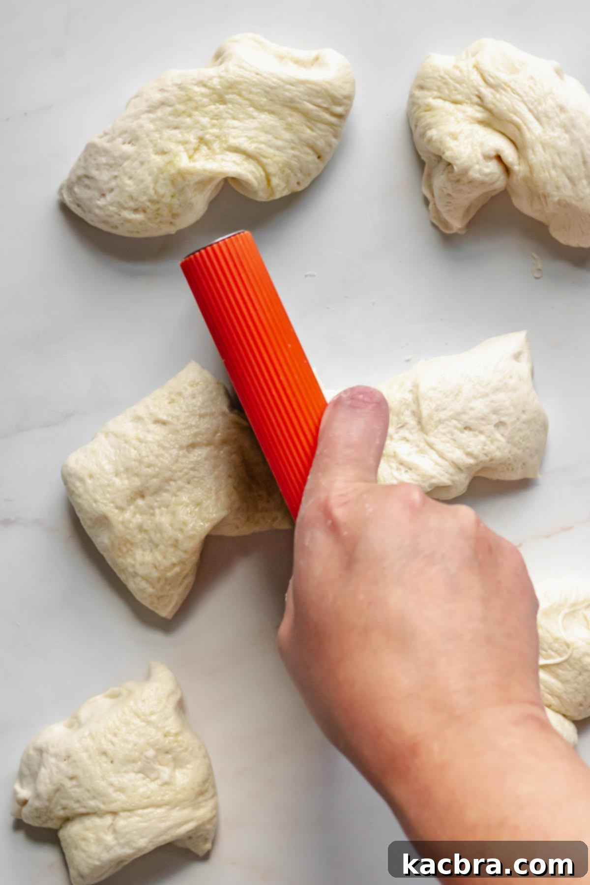 Cutting pretzel dough in half.