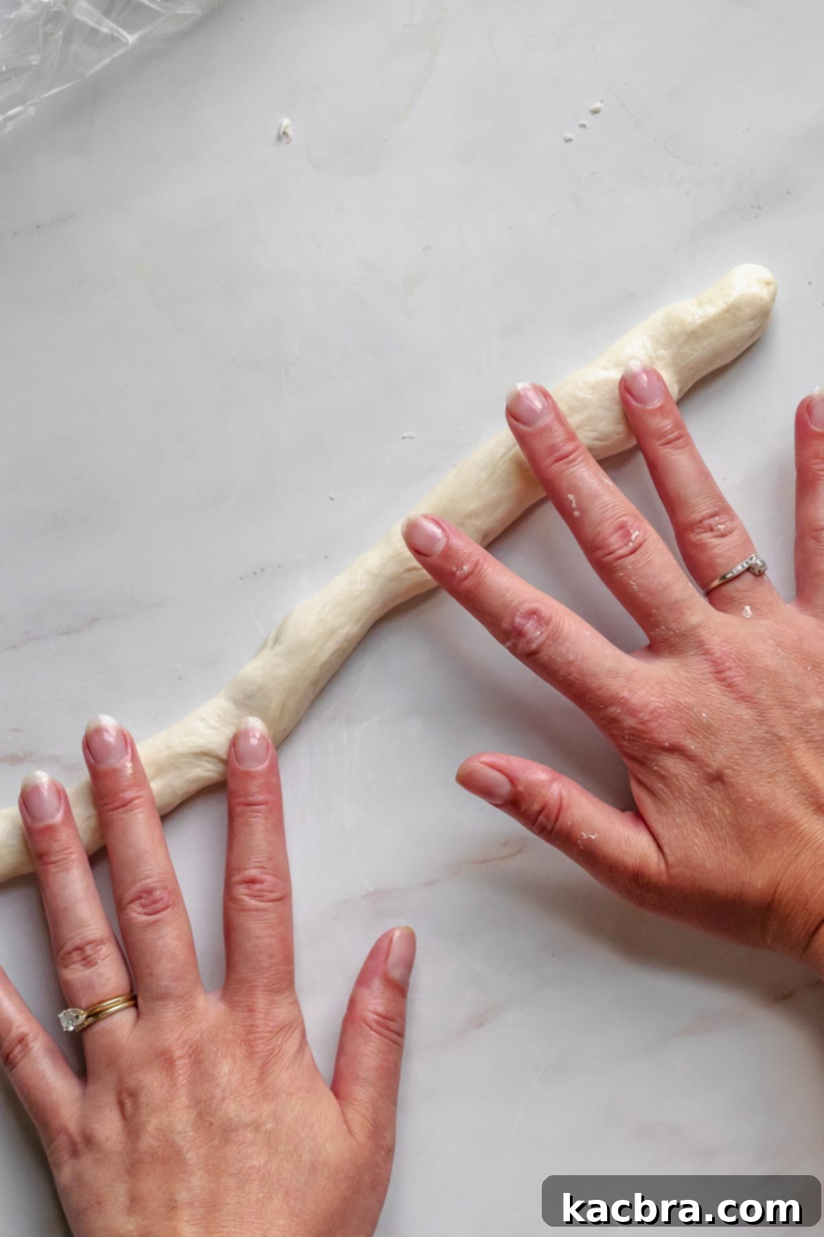 Rolling pretzel dough into a log.