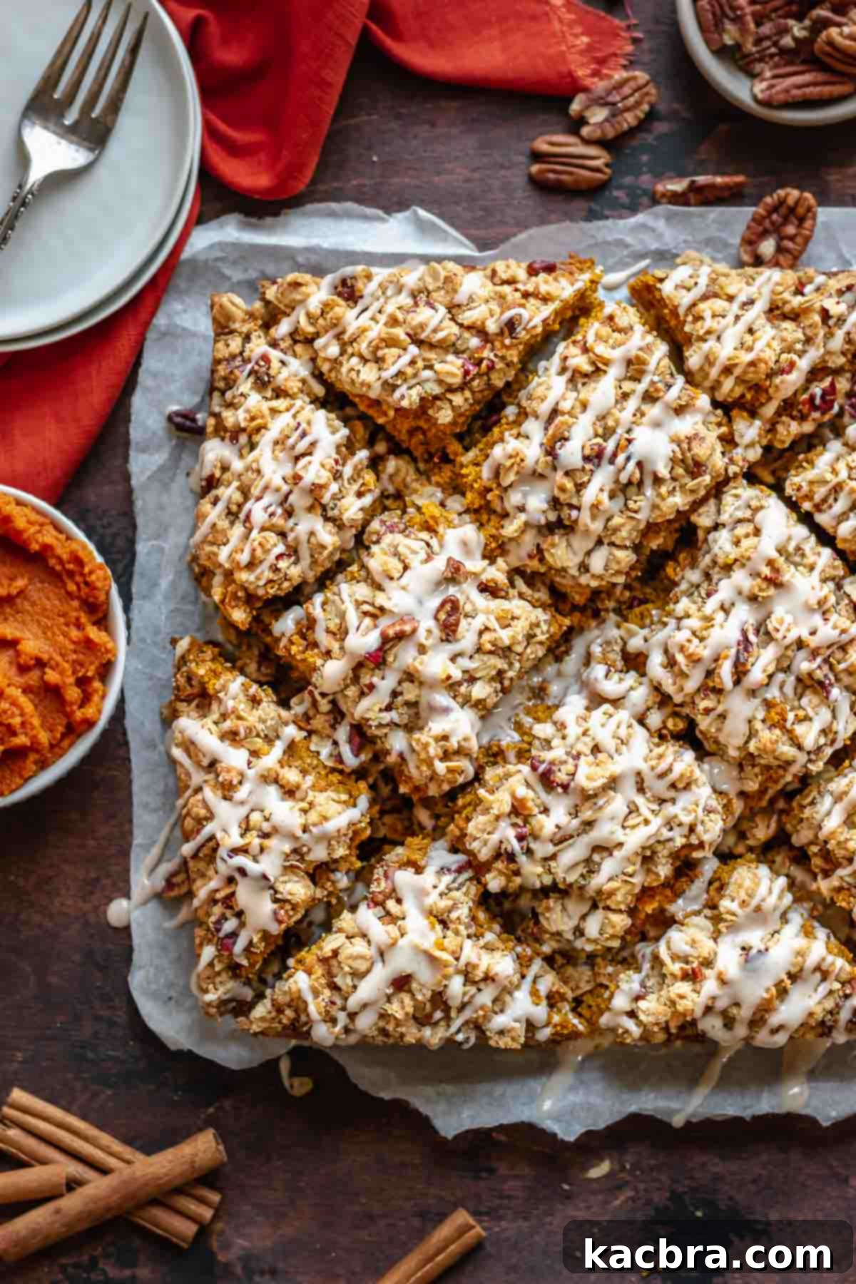 A cut pumpkin coffee cake, generously drizzled with cinnamon icing, ready to be served.