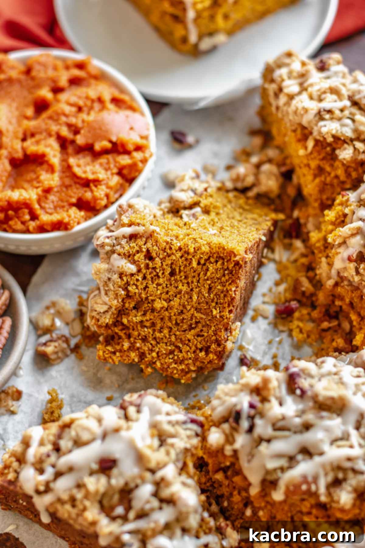A slice of pumpkin coffee cake resting on its side, showing the dense cake and crispy topping.