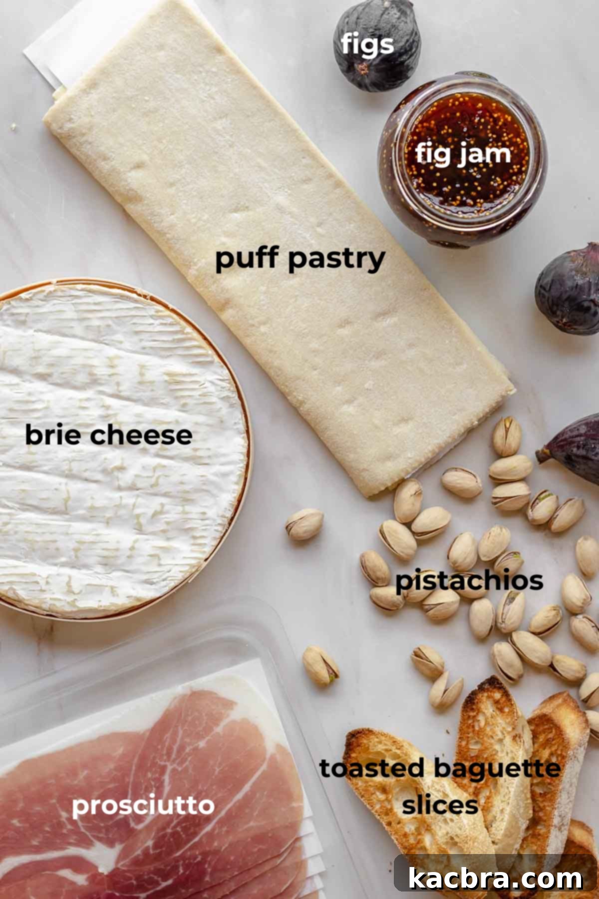 A flat lay of all the ingredients needed to make baked brie with fig jam, including puff pastry, a wheel of brie, fig jam, and an egg.