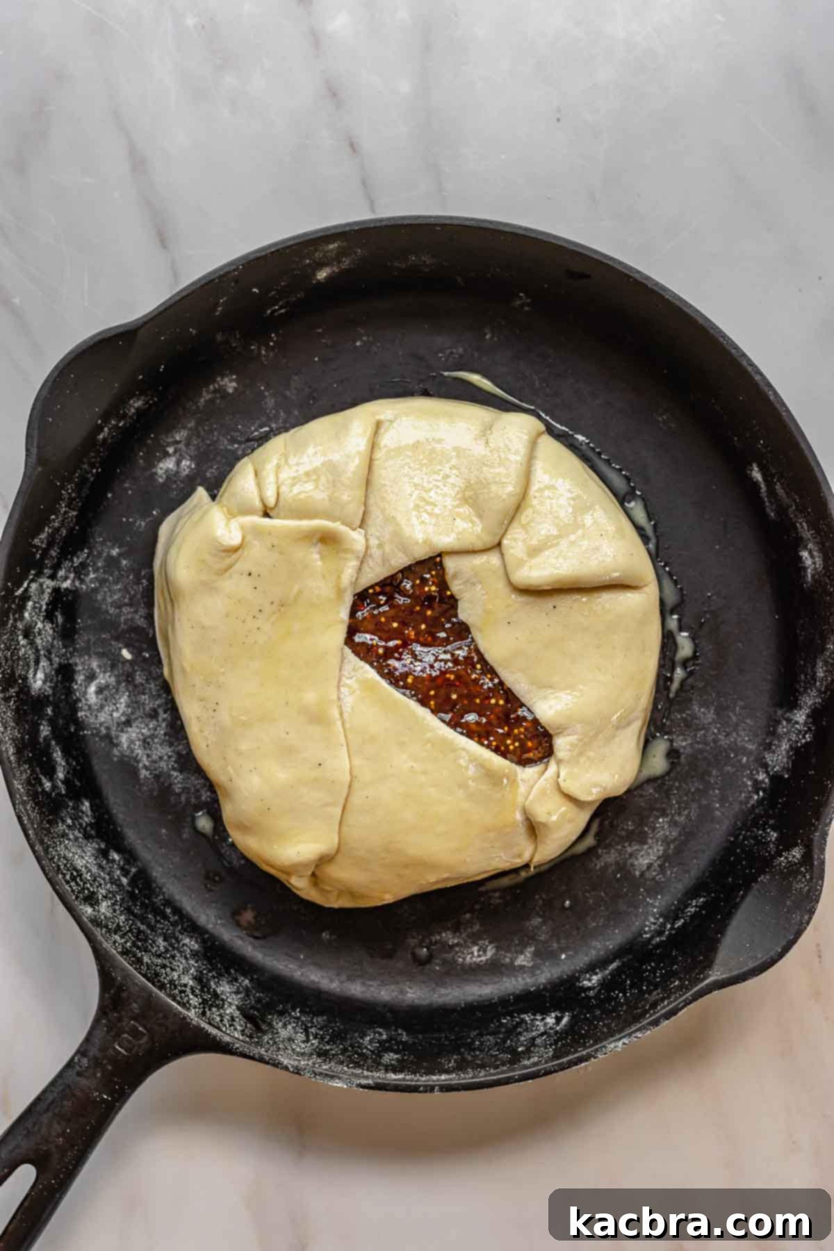 The puff pastry fully folded around the brie, brushed with egg wash and ready for baking.