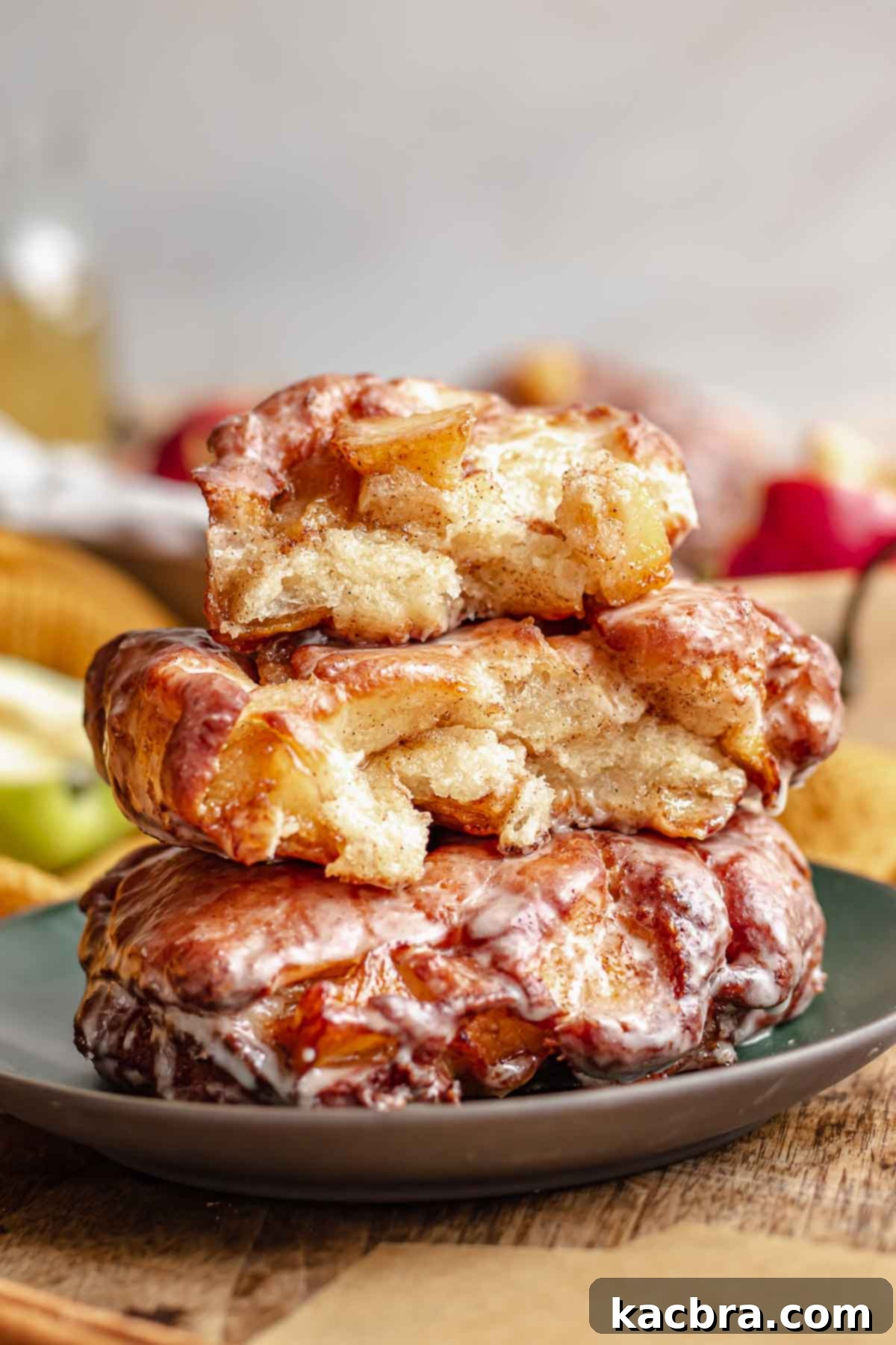 A stack of golden-brown apple fritters glistening with glaze, ready to be enjoyed.