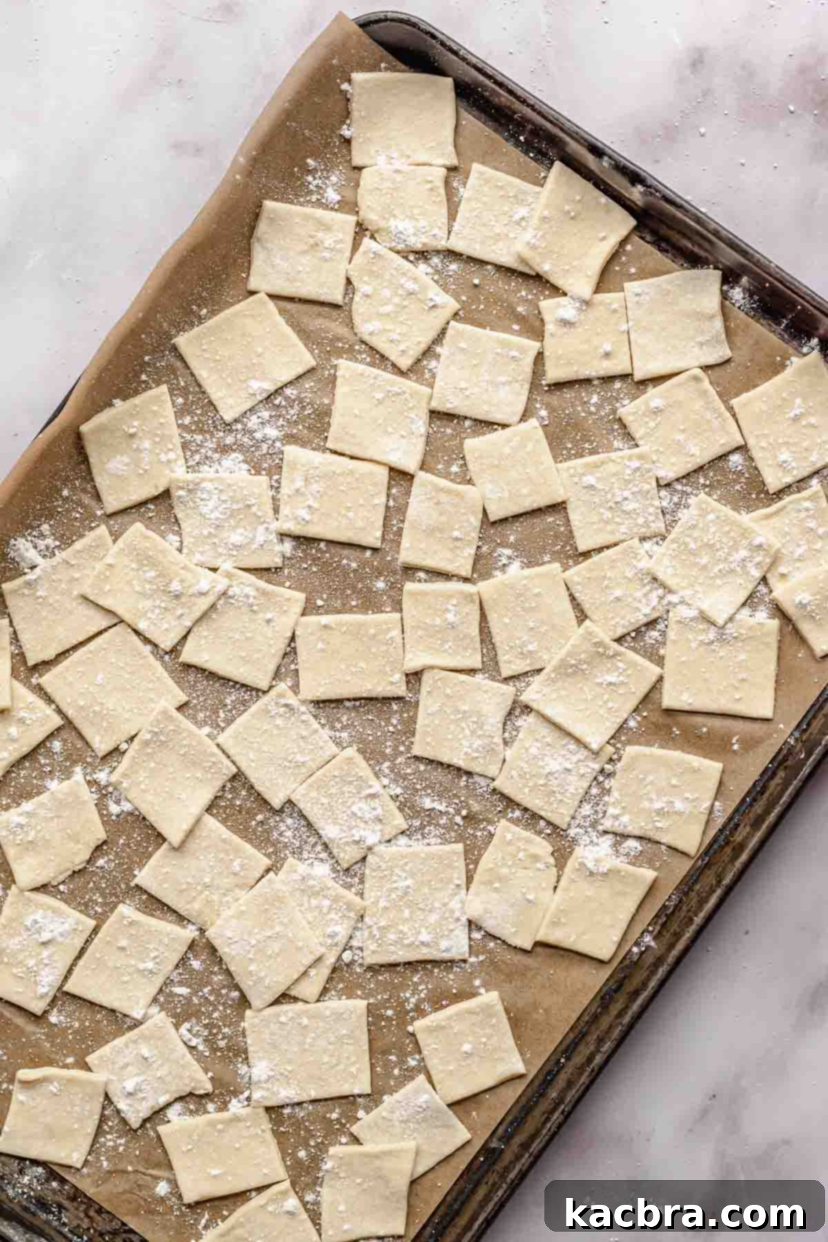 Raw pot pie noodles on a sheet tray with flour.