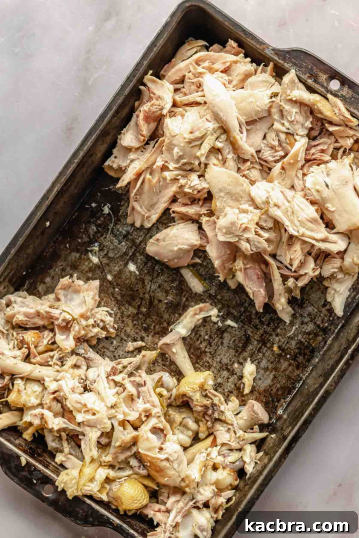 Picked chicken leg quarters. One side holds bones and skin, the other holds meat.