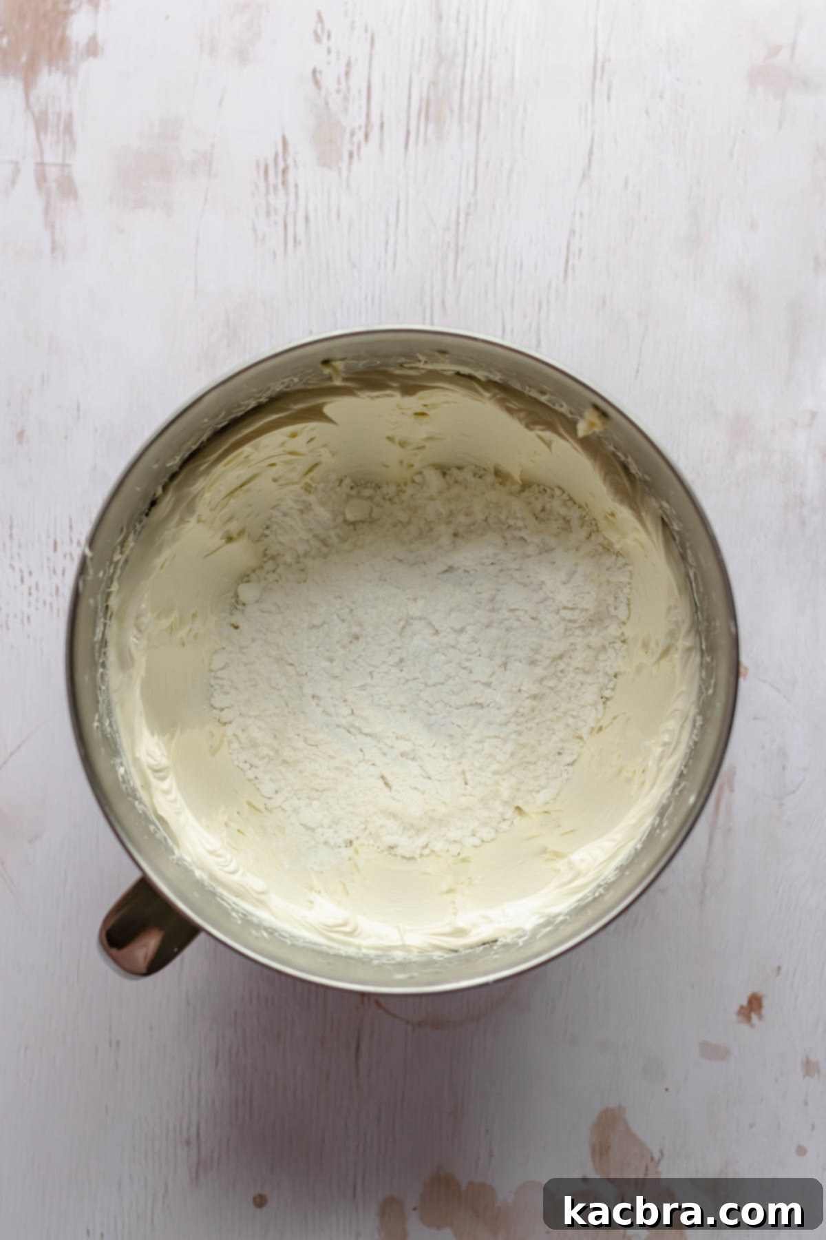 Creamed butter and powdered sugar are shown in a mixing bowl, ready to be beaten together for the espresso buttercream frosting.