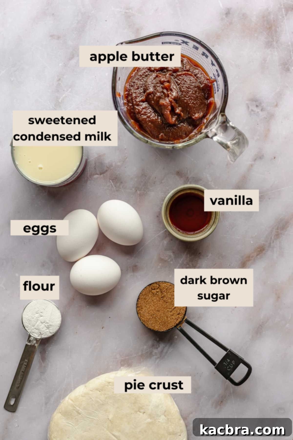 All the essential ingredients for making a delicious apple butter pie are neatly arranged on a rustic wooden surface, ready for baking.