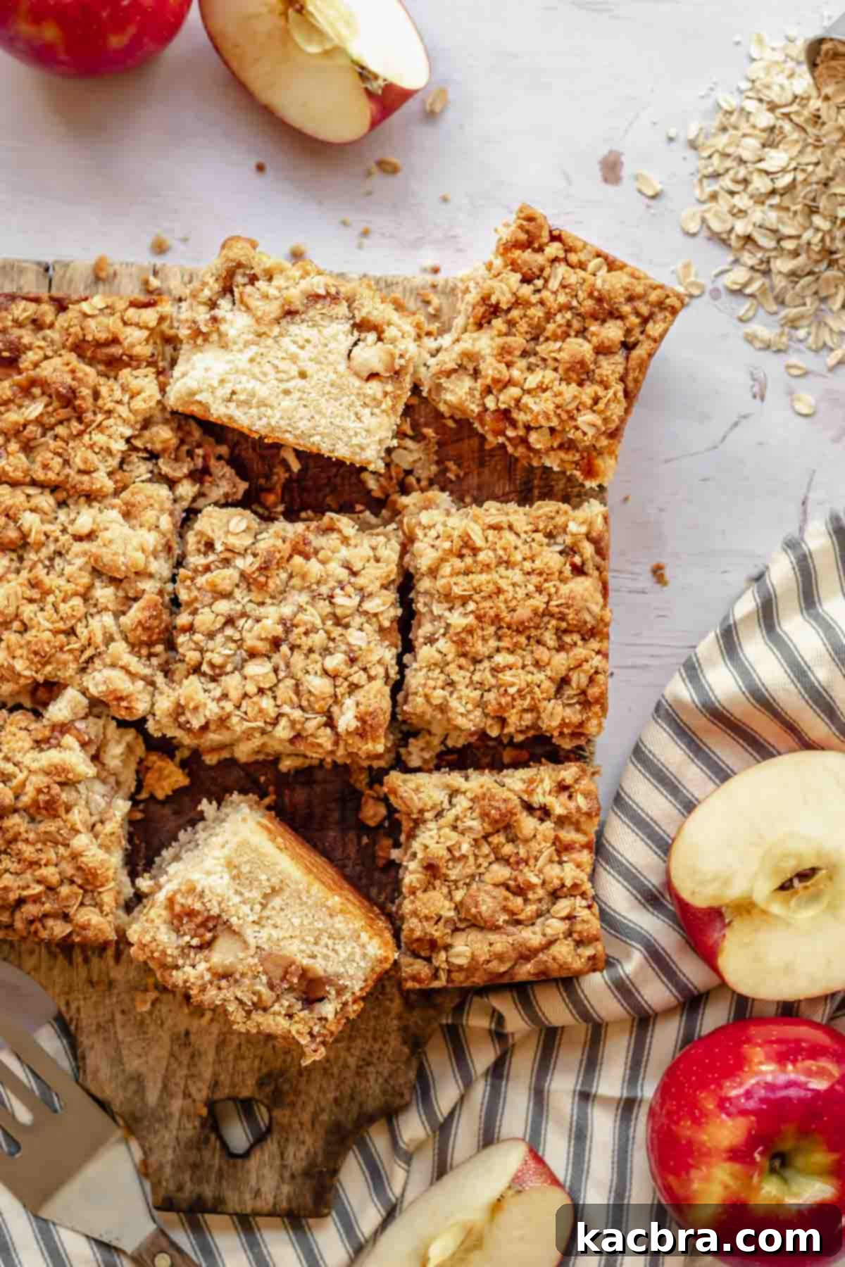 Generous slices of apple streusel coffee cake on a rustic wooden board, showcasing the layers of cake, apples, and streusel.