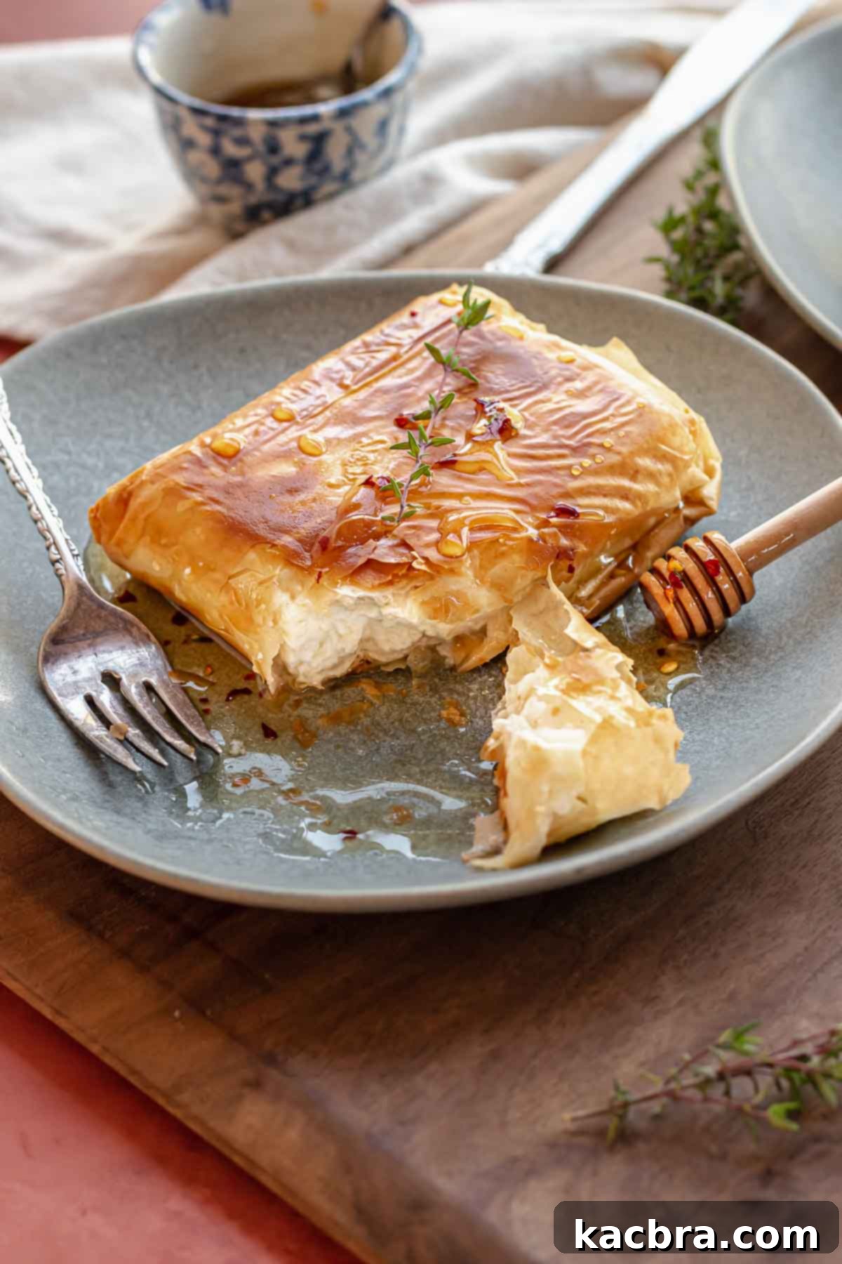 Fried feta on a plate cut open with a fork on the plate.