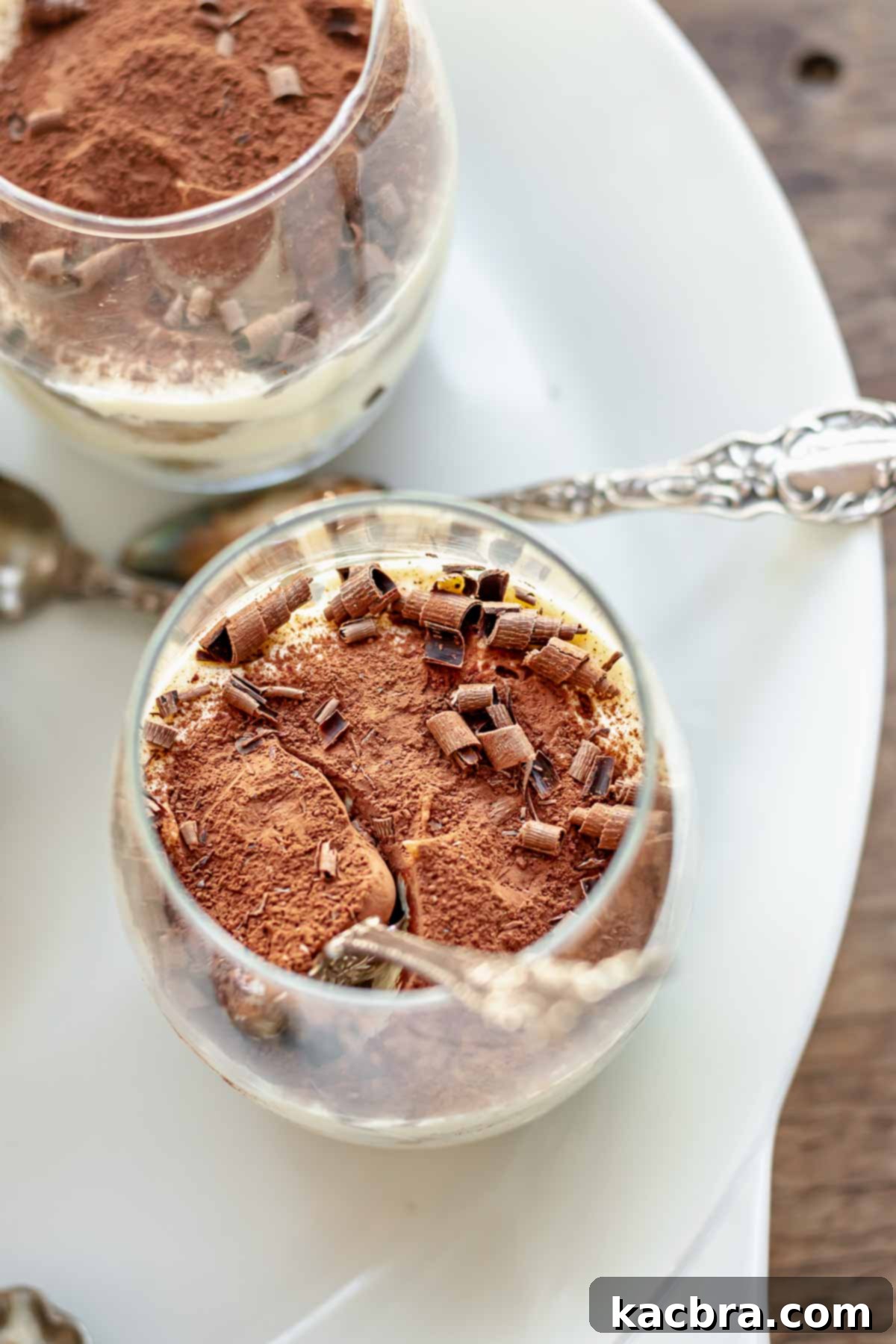 A tiramisu cup with a spoon in it.