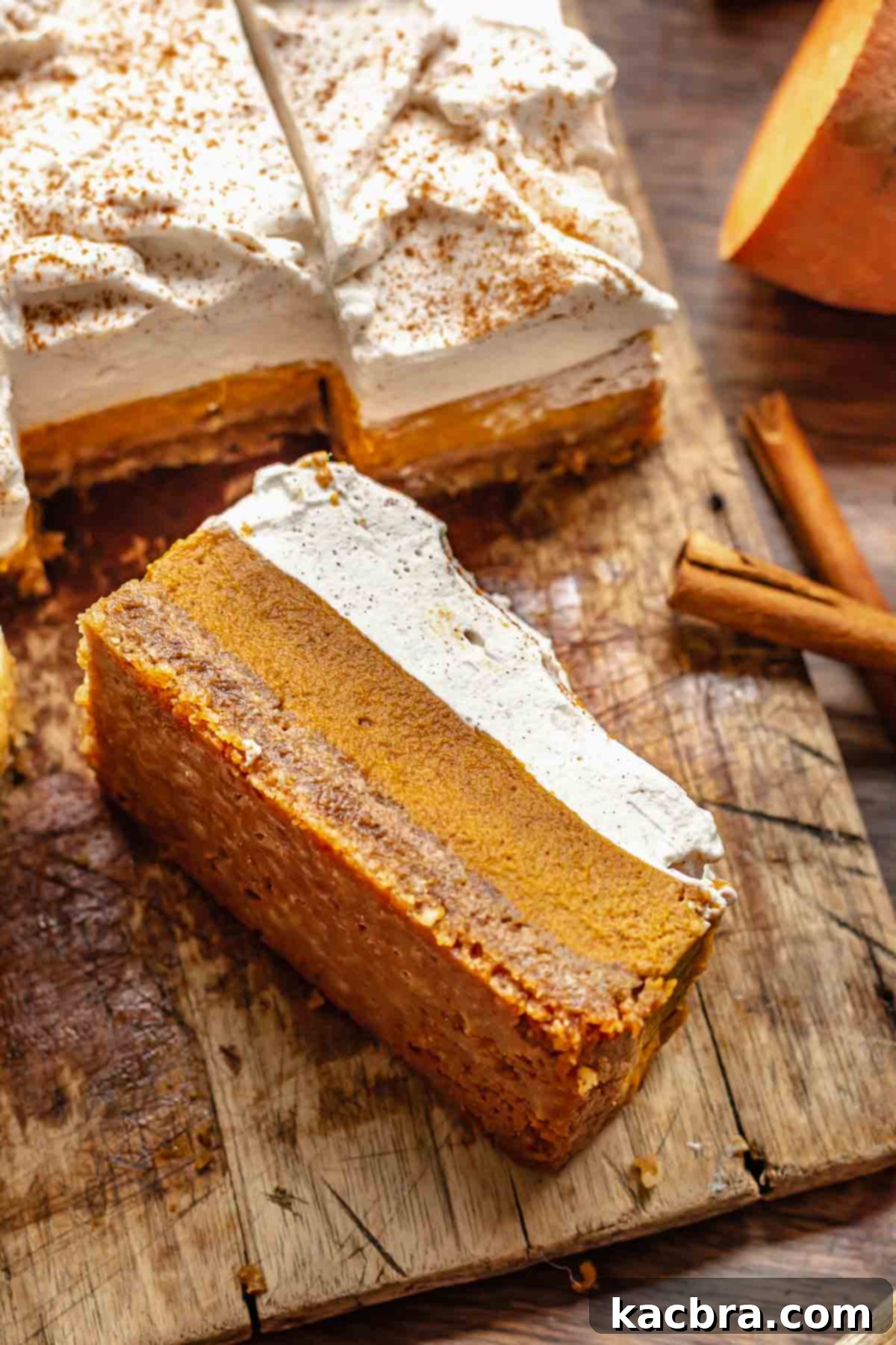 A beautifully presented slice of sweet potato pie bar resting on its side on a rustic cutting board, showcasing its distinct layers.