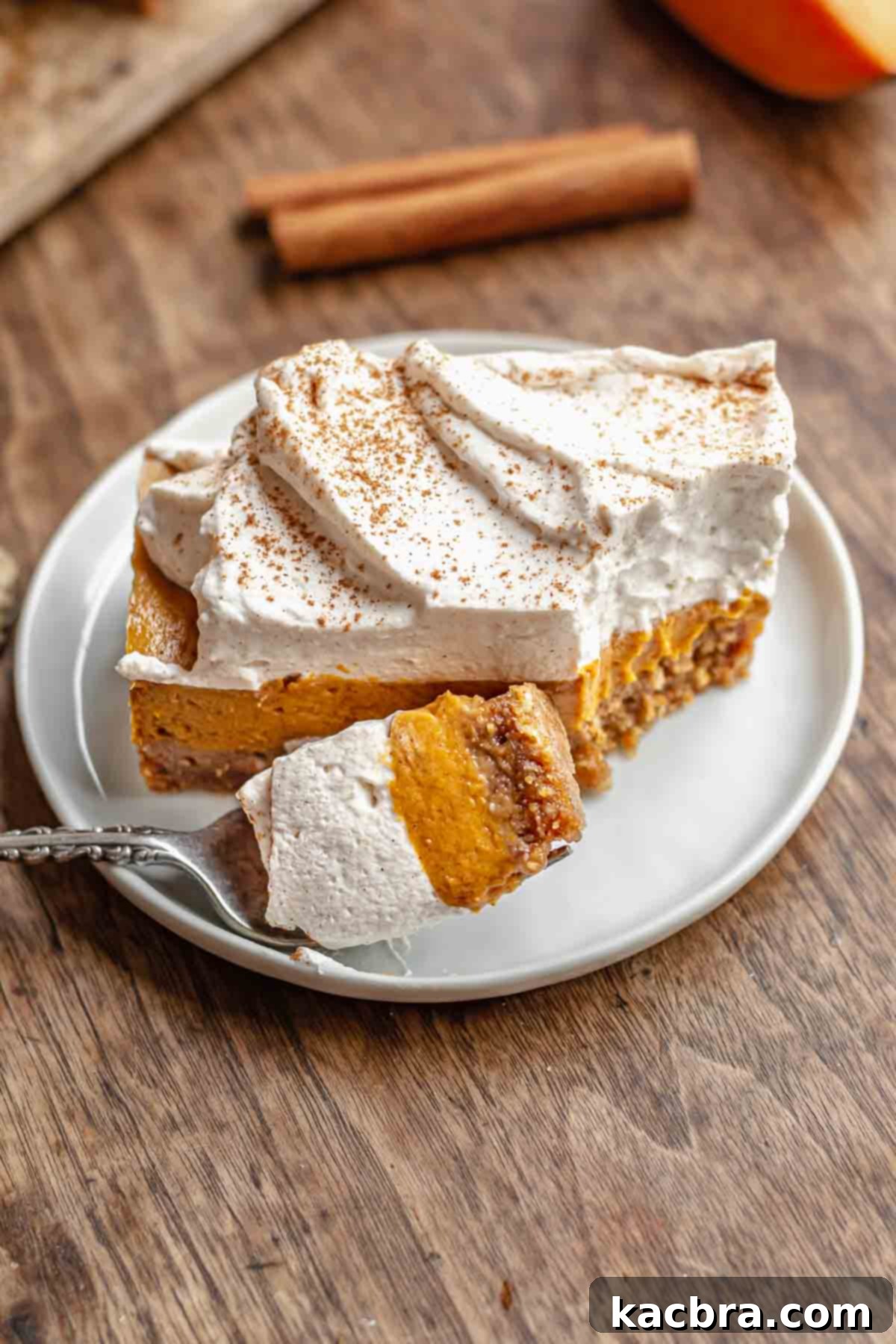 A sweet potato pie bar on a plate with a bite taken out, revealing the creamy filling and crunchy crust.