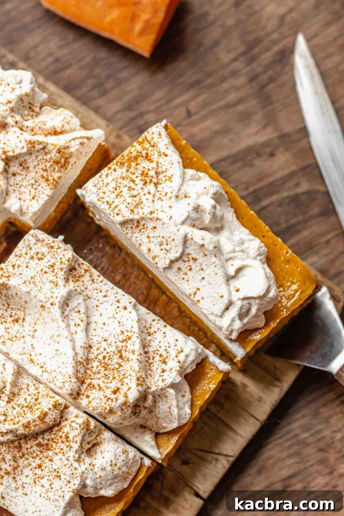 A spatula carefully lifting a perfect slice of sweet potato pie bar from the pan.