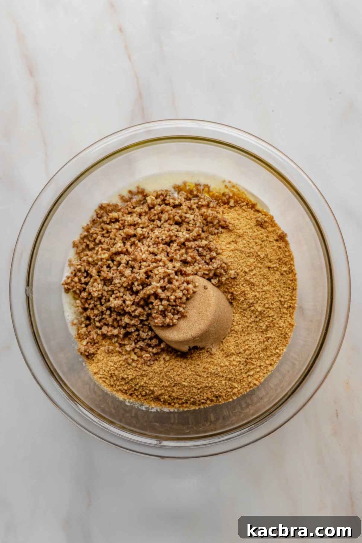 Graham cracker pecan crust ingredients in a mixing bowl, ready to be combined.
