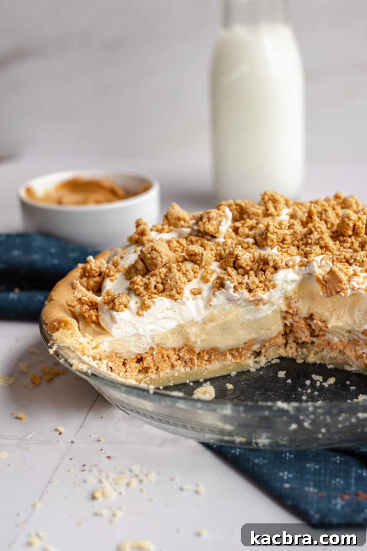 An Amish peanut butter pie in a pie dish with several slices already removed, showing the layers.