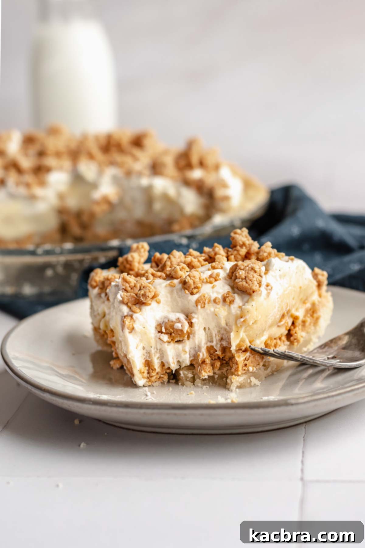 A perfectly sliced piece of Amish peanut butter pie on a white plate, ready to be enjoyed with a fork.