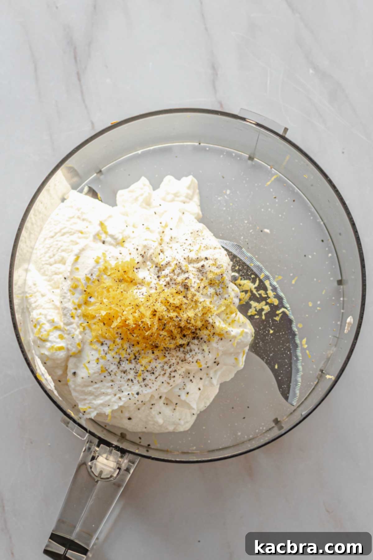 Fluffy Ricotta Crostini 7 Ricotta cheese, lemon zest, salt and pepper in a food processor bowl.