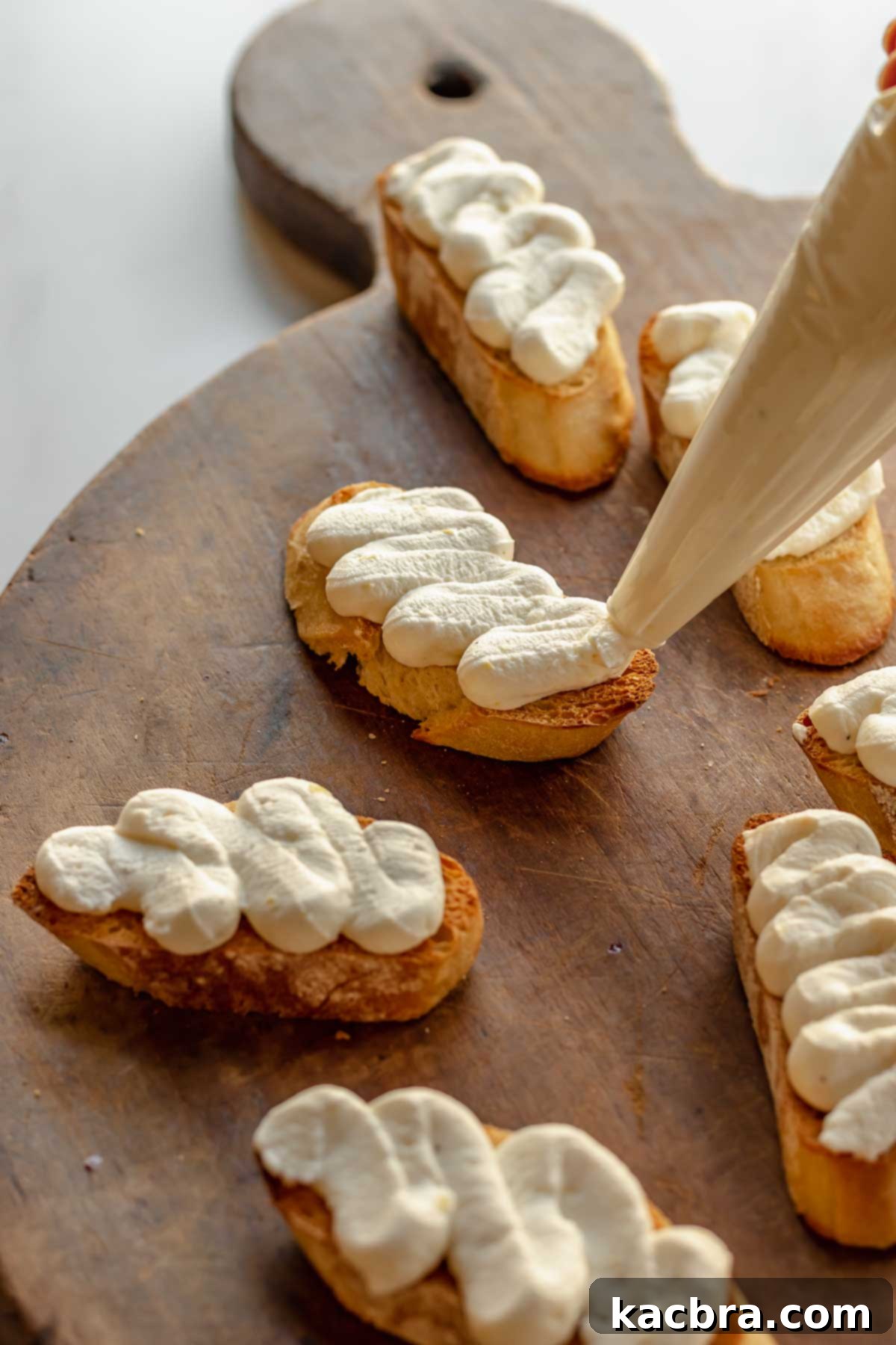 Fluffy Ricotta Crostini 9 A piping bag pipes squiggles of whipped ricotta onto toasted baguette slices.