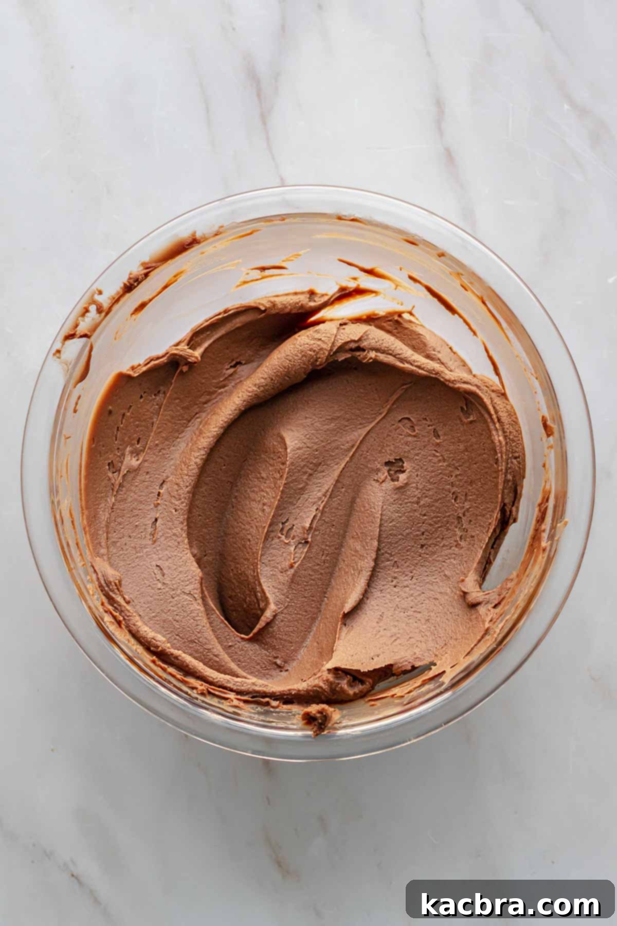 Decadent Chocolate Orange Bliss 11 A bowl of rich, milk chocolate orange ganache, perfectly set to a thick, creamy, and spreadable consistency, ready to be used as a cake filling.