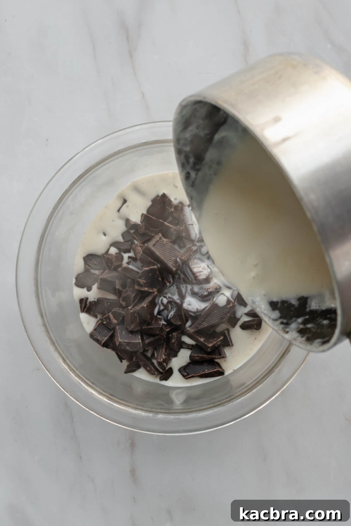 Decadent Chocolate Orange Bliss 14 Steaming heavy cream pours into a bowl of chopped dark chocolate, beginning the process of making ganache.