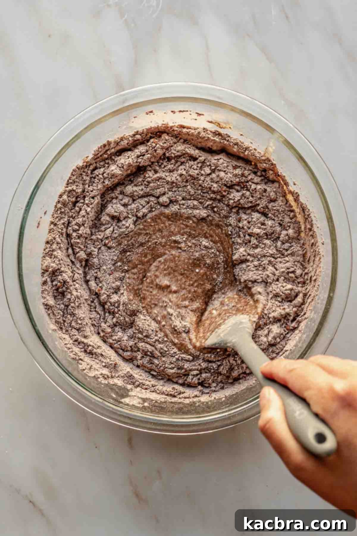 Decadent Chocolate Orange Bliss 8 A rubber spatula is used to gently fold and mix the chocolate cake batter, ensuring all dry pockets are incorporated without overmixing.