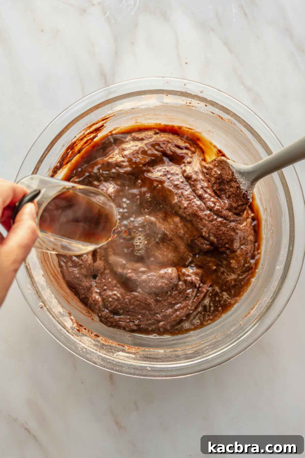 Decadent Chocolate Orange Bliss 9 Steaming hot coffee is being poured into the rich chocolate cake batter, ready to be gently folded in to enhance the chocolate flavor and moistness.