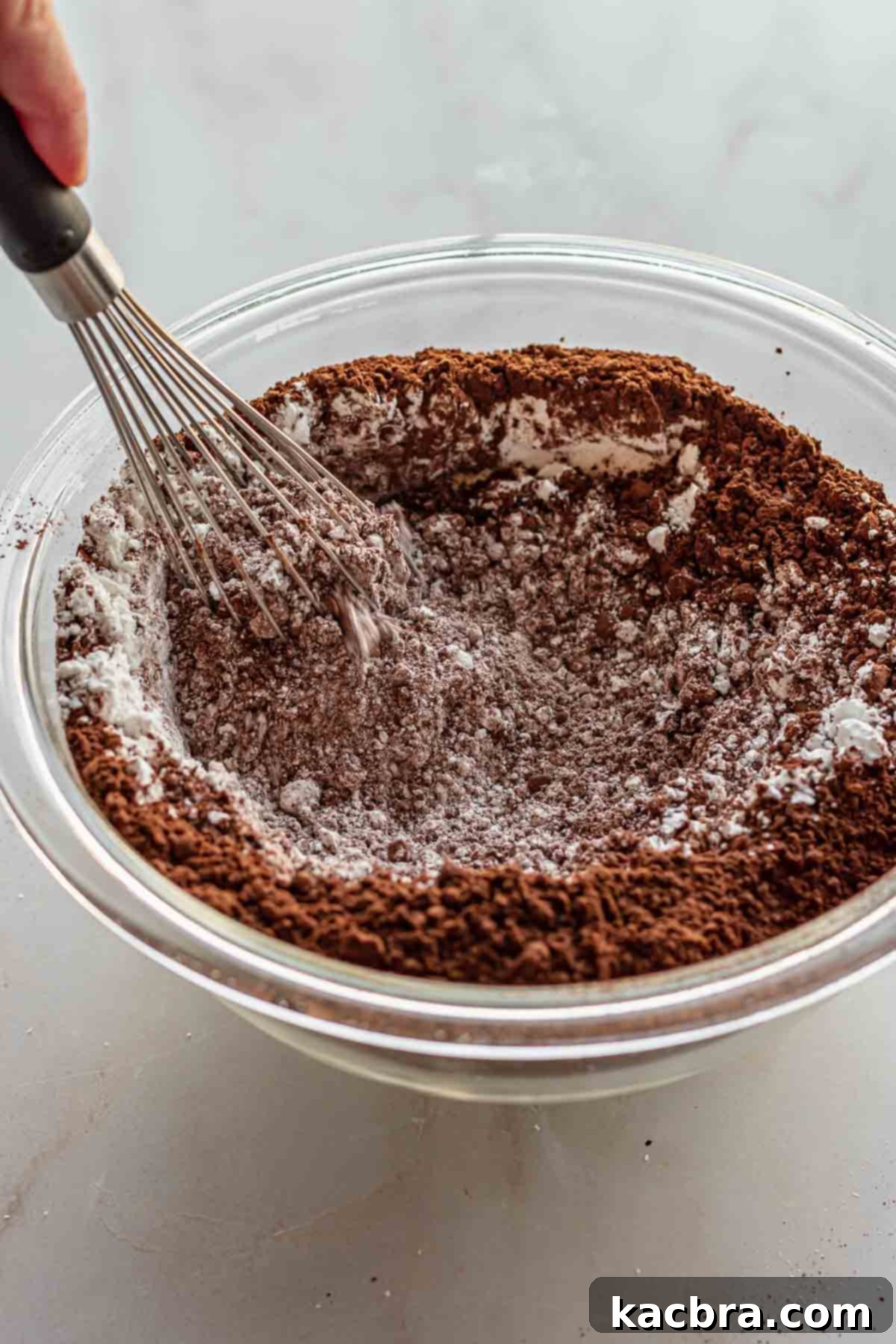Dry ingredients in a bowl with a whisk.
