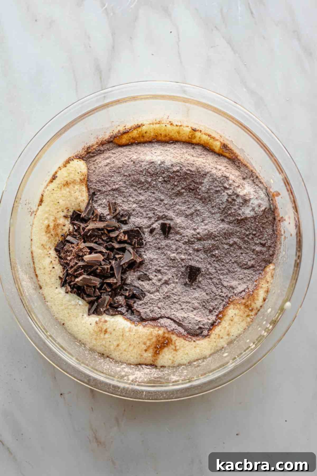 Dry ingredients and chopped chocolate in a bowl with wet ingredients.