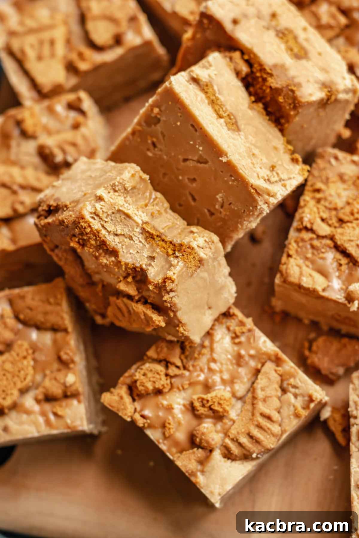 Piles of rich, creamy Biscoff fudge cubes leaning on each other, showcasing their delightful texture and cookie speckles.